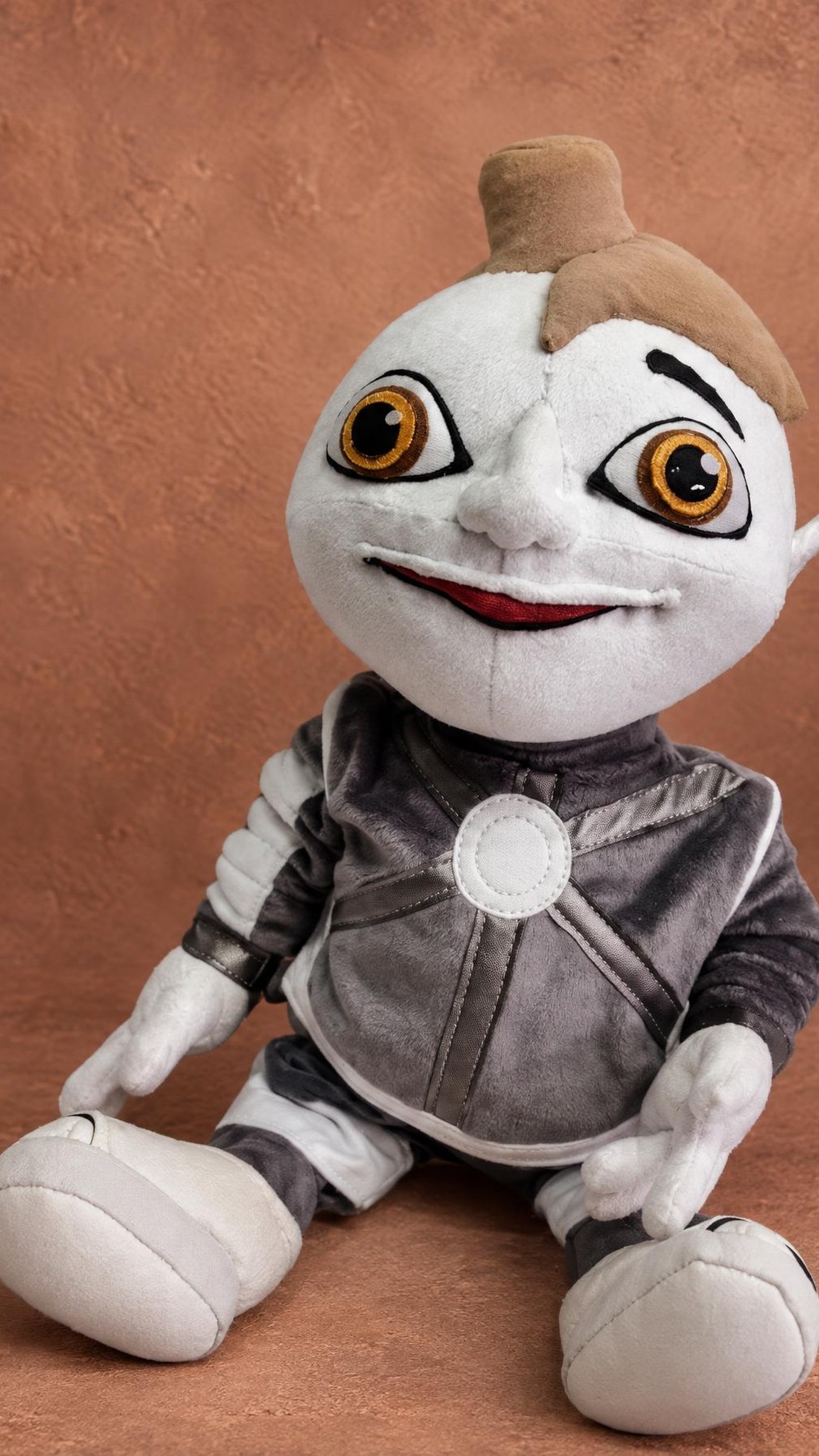 Arif 216 plush sitting in his grey spacesuit with white boots, a custom Arif V 216 robot toy made to order