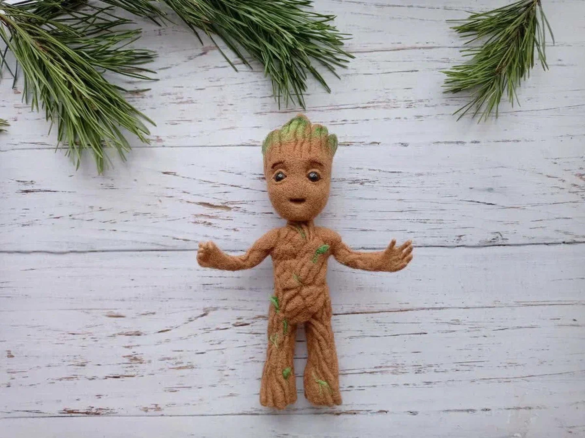 Baby Groot plush with his arms open Baby Groot plush with his arms open among pine branches, a needle-felted Marvel character made to order