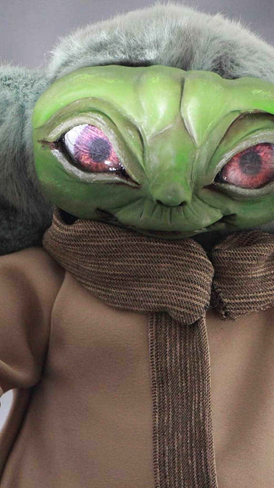 Baby Yoda doll face with big handmade eyes and a clay face painted green, a custom Grogu doll made to order