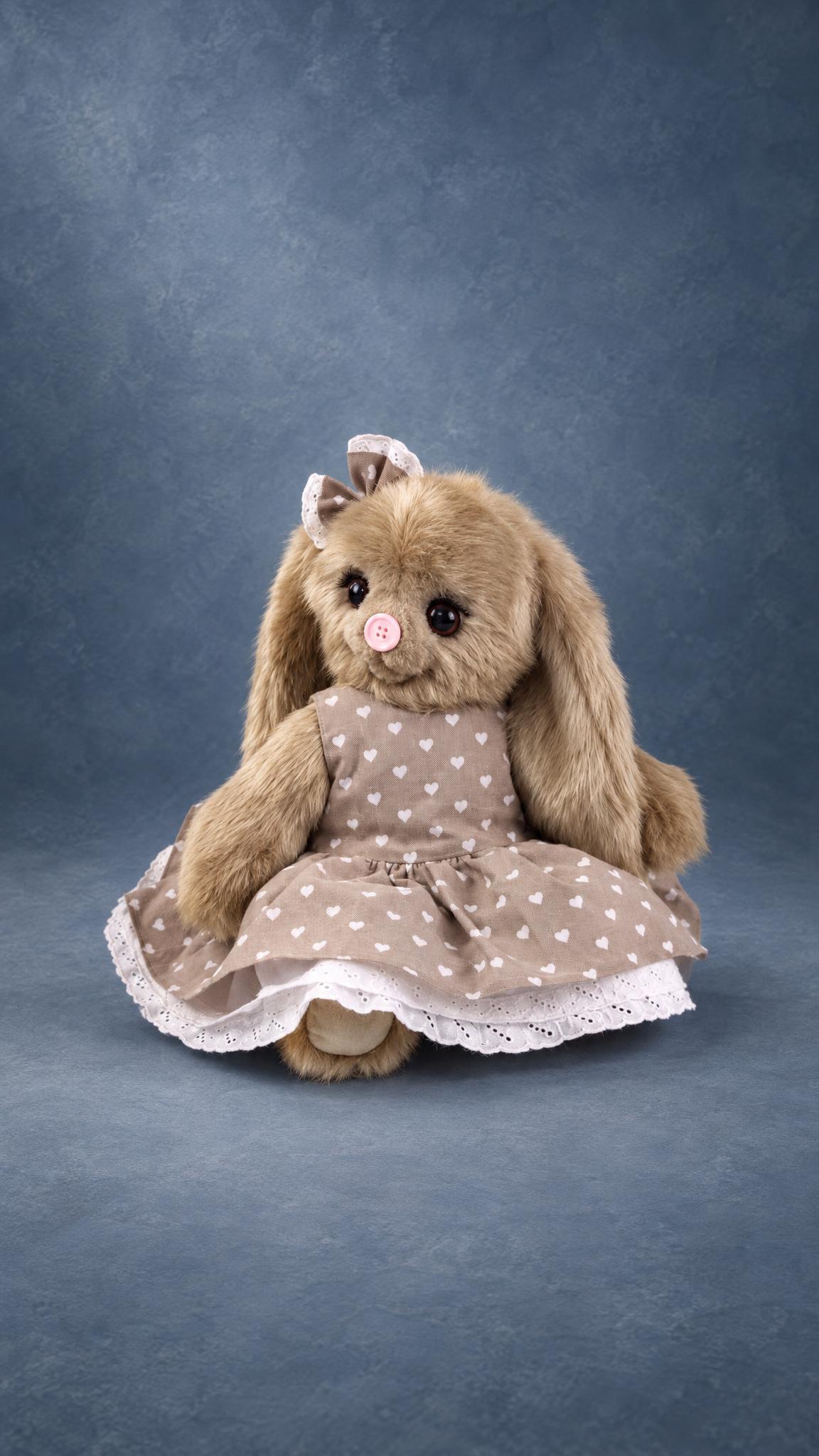 Beige bunny plush in a heart-print dress with a white lace hem, a handmade prototype for a toy brand