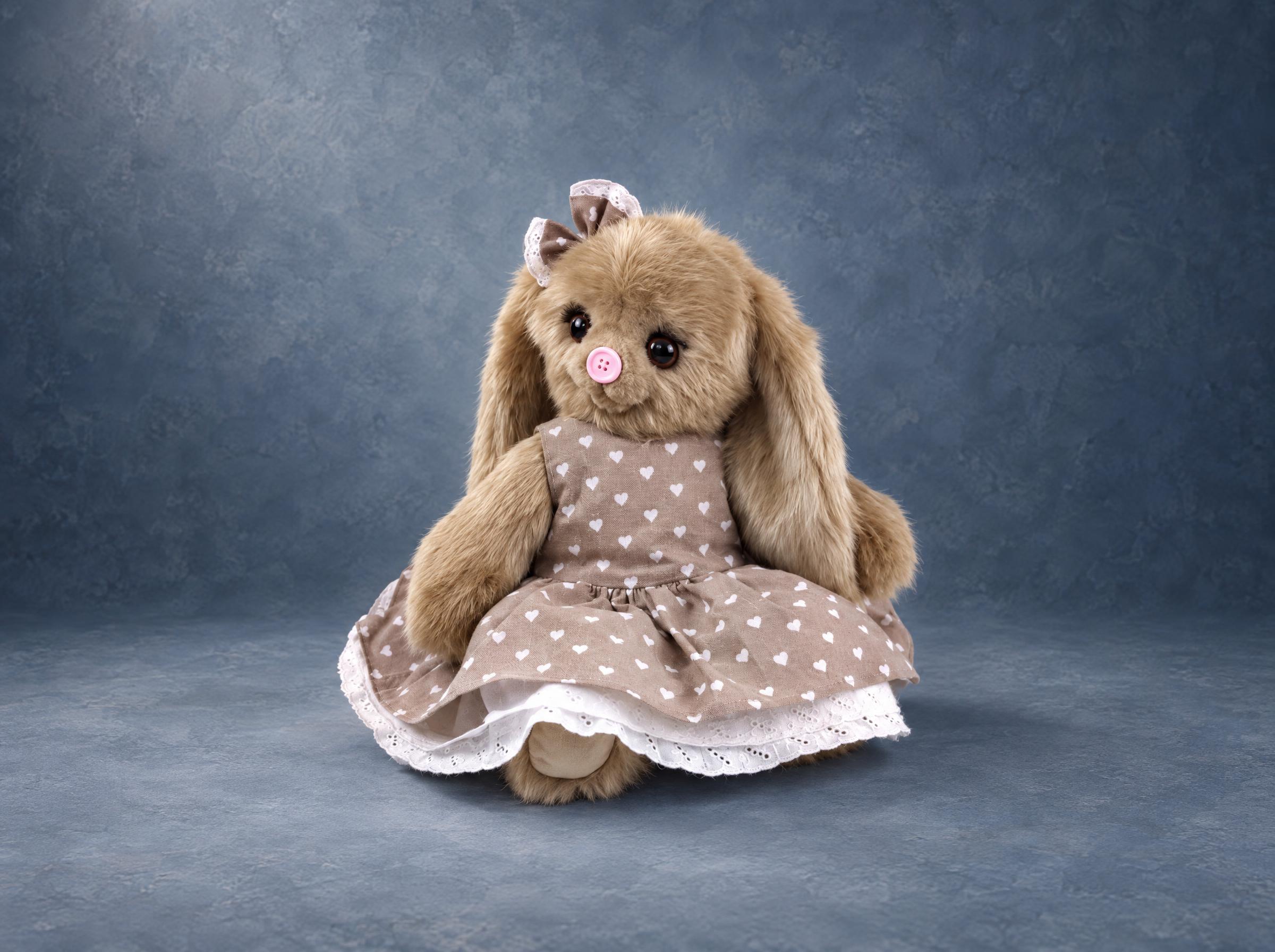 Beige bunny plush in a heart-print dress Beige bunny plush in a heart-print dress with a white lace hem, a handmade prototype for a toy brand