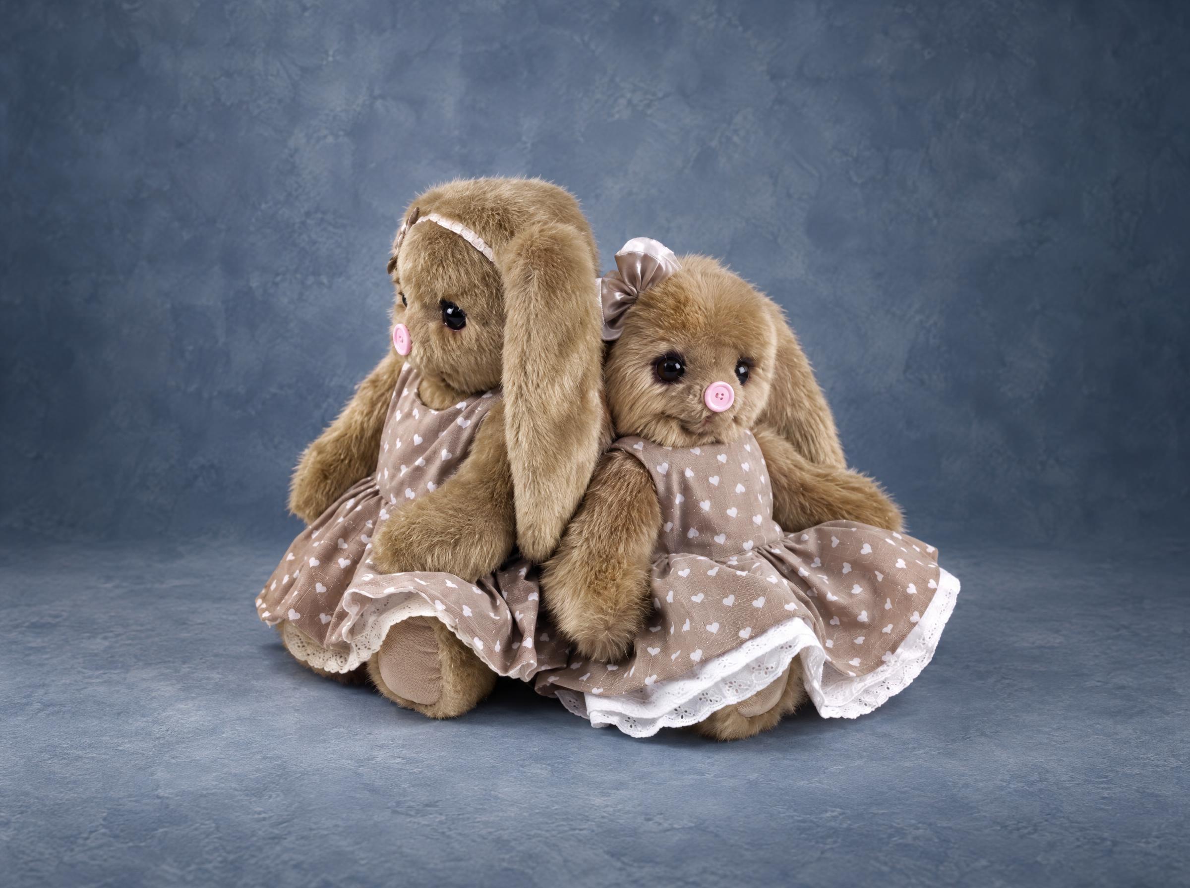 Beige bunny plush samples in heart-print dresses Beige bunny plush samples in matching heart-print dresses with lace hems, custom prototypes for a toy brand