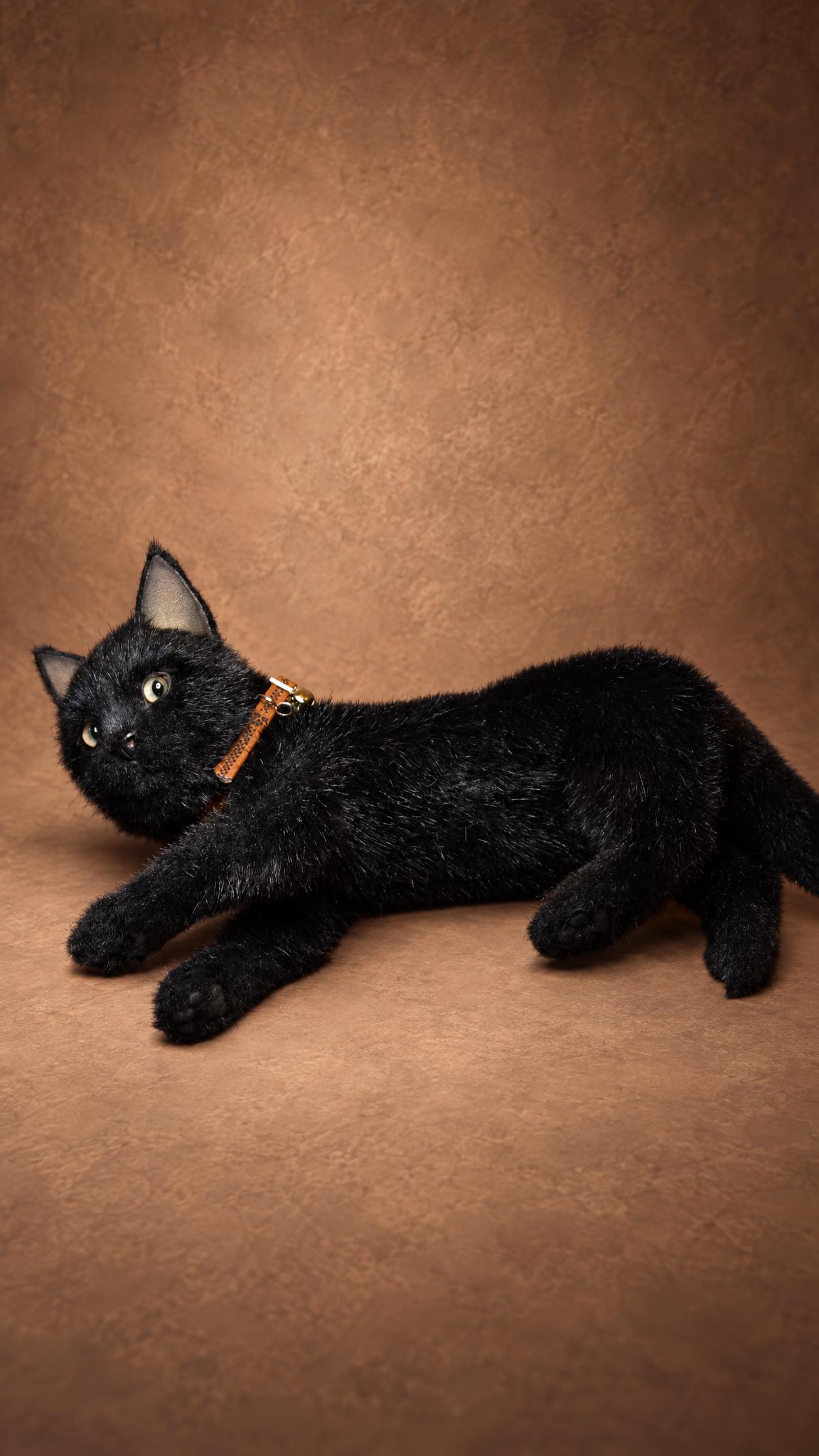 Poseable black cat plush lying on its side, a realistic stuffed animal handmade to order