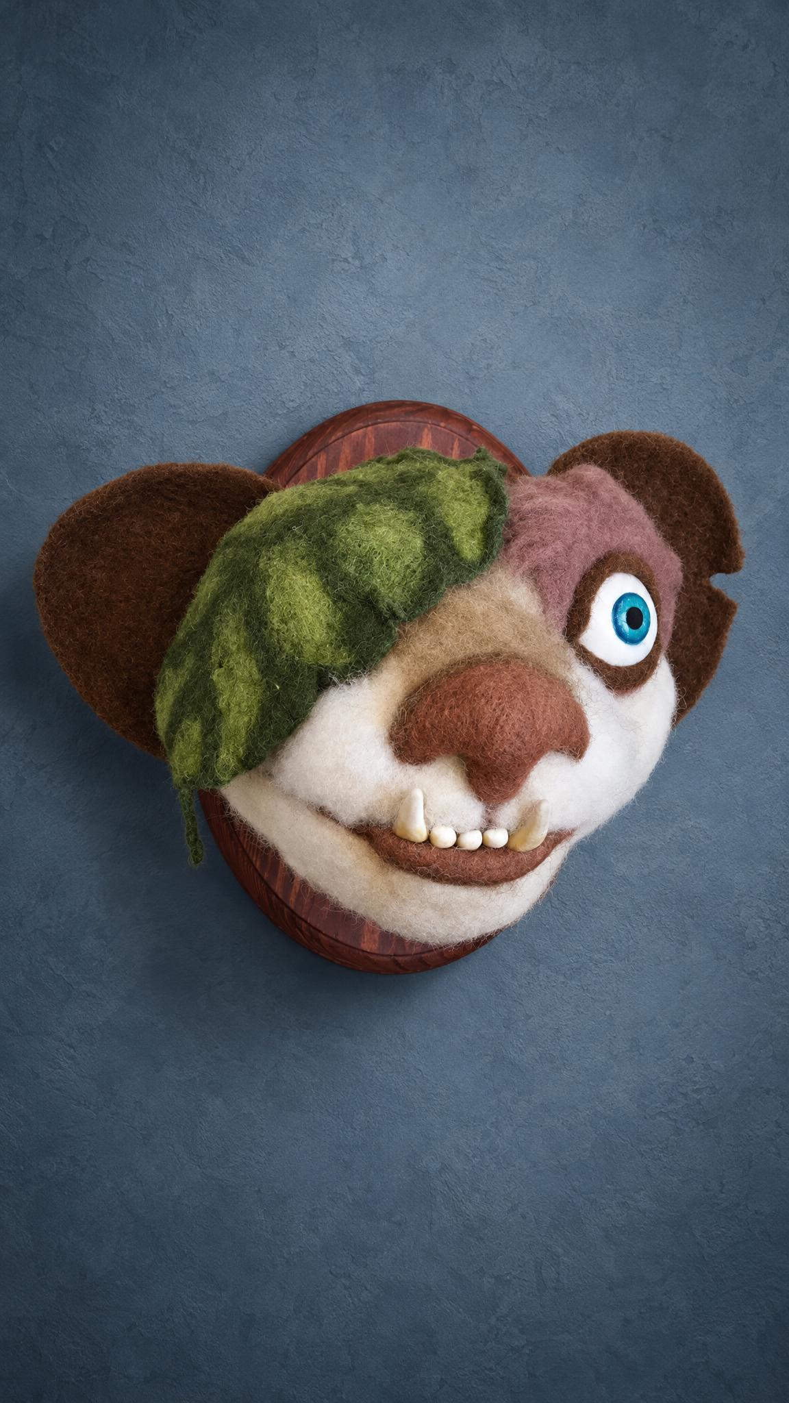 Ice Age Buck faux taxidermy head in felted wool, leaf over one eye and a crooked fanged grin, handmade to order