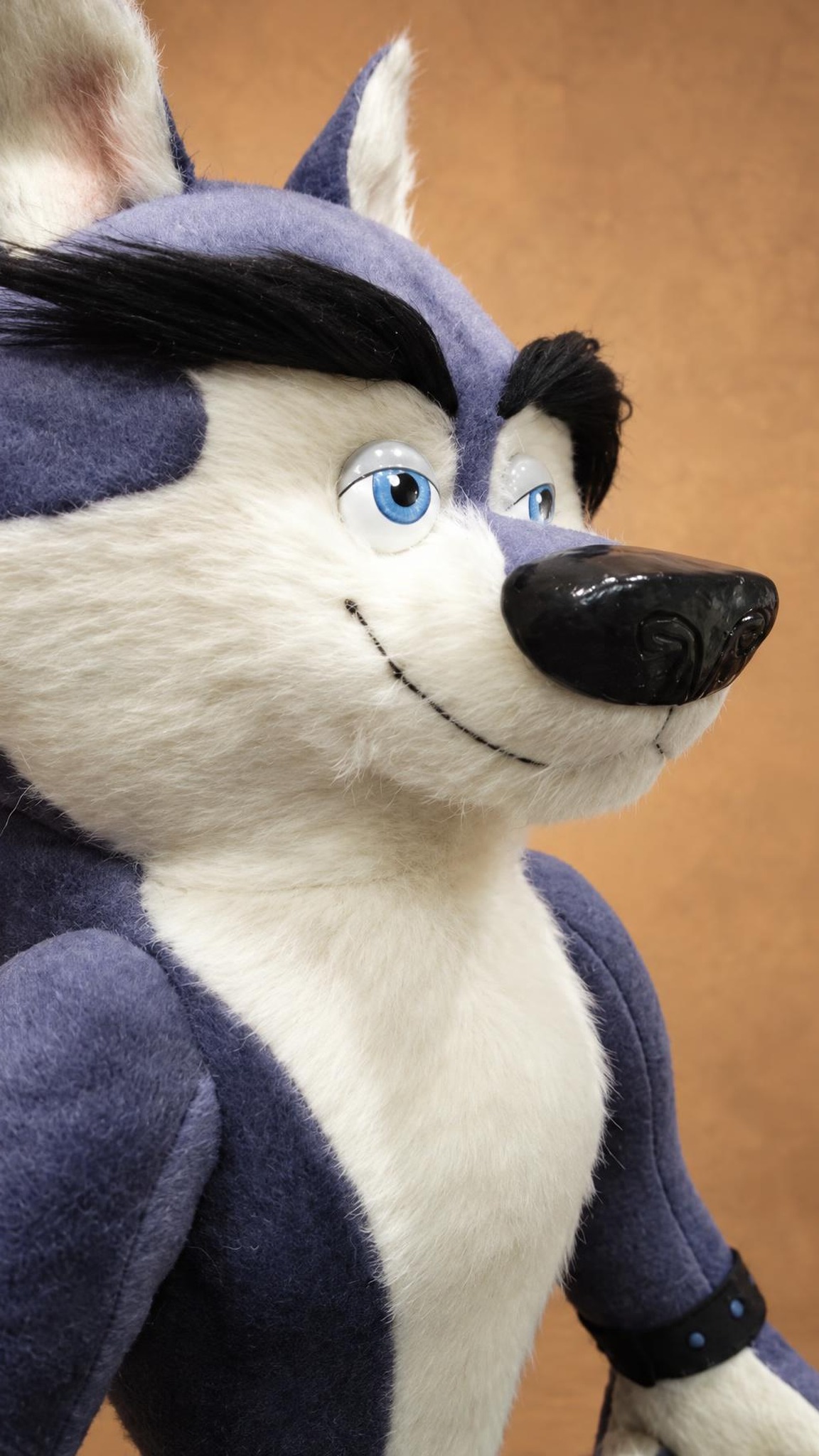 Classified wolf plush face with glossy black nose, pale blue eyes and black faux-fur brows, custom made