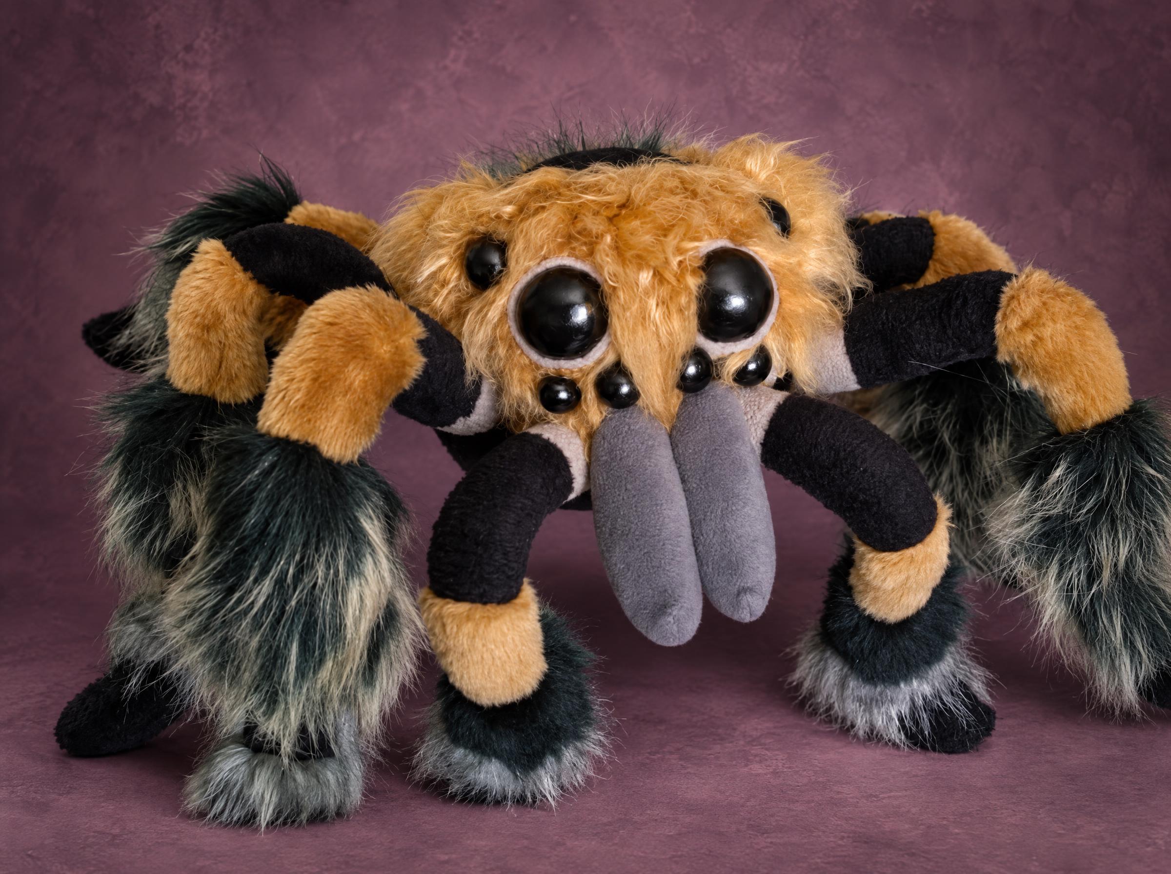 Creepy spider plush with big shiny black eyes, gray fangs, an orange furry body and shaggy striped legs, made to order
