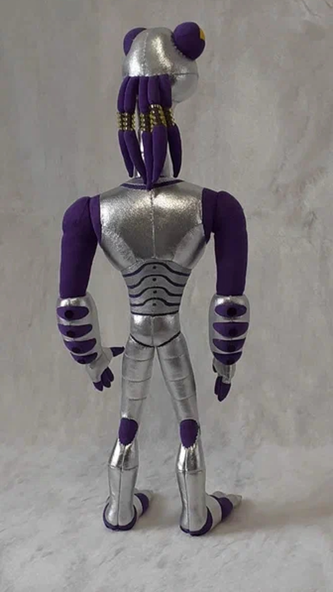 Back of the Croakagy plush: purple head tendrils with gold bands and silver striped back, sewn to order