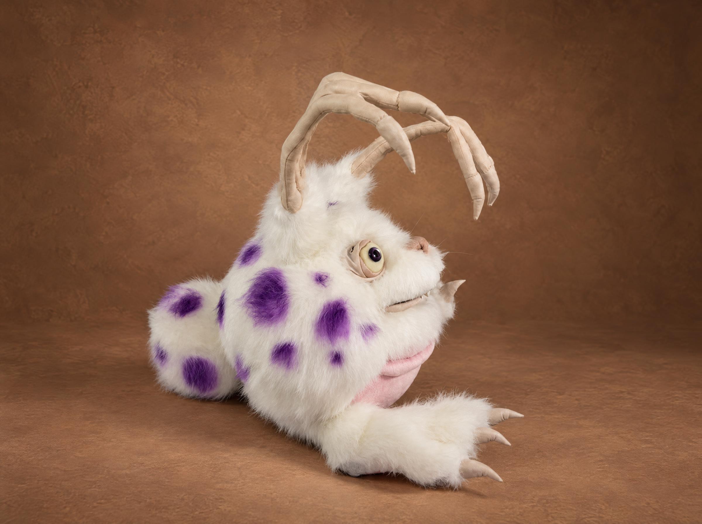 Custom Blabbit plush with purple spots, My Singing Monsters Custom Blabbit plush lying on its belly, purple spots on white faux fur and finger-shaped ears, sewn to order