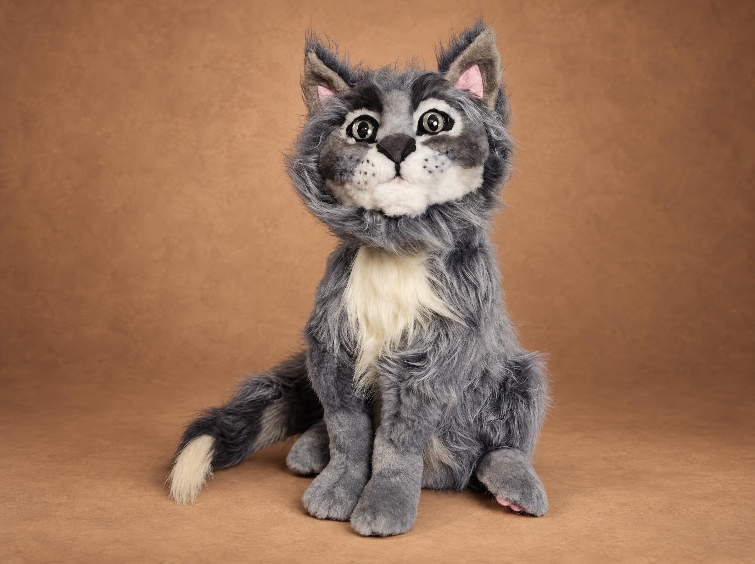 Custom cat stuffed animal of a grey cat, sitting with a pink paw pad showing and a cream-tipped tail, made to order