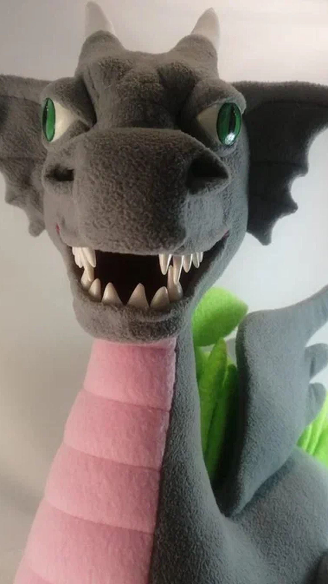 Custom dragon mascot plush with a pink ribbed belly and a wide open grin, gray fleece, made to order for a team
