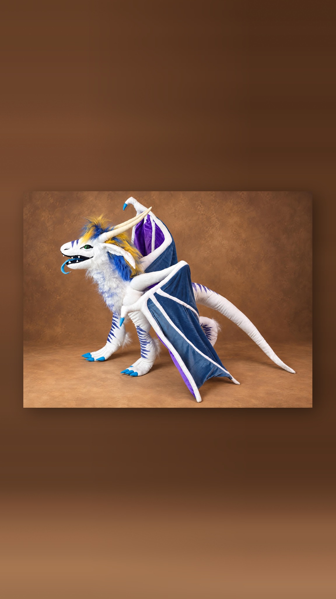 Custom ice dragon plush with a steel-blue wing lowered to the floor and a white fur ruff, handmade to order
