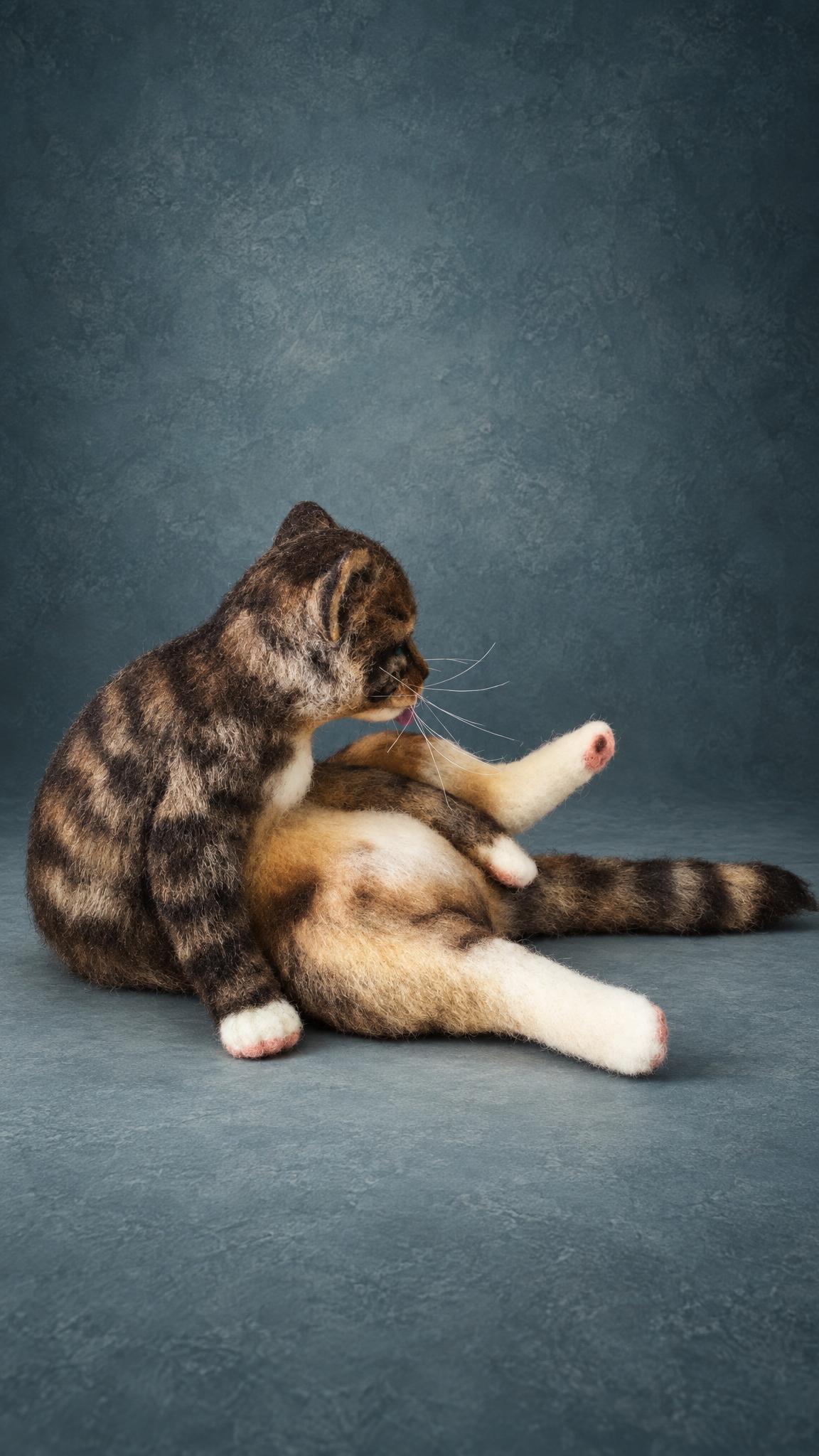 Custom needle felted cat in a grooming pose, striped tabby coat and white paws, handmade to order