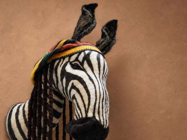 Custom zebra head plush, handmade faux taxidermy with hand-sewn stripes, a striped cap and braided yarn locks