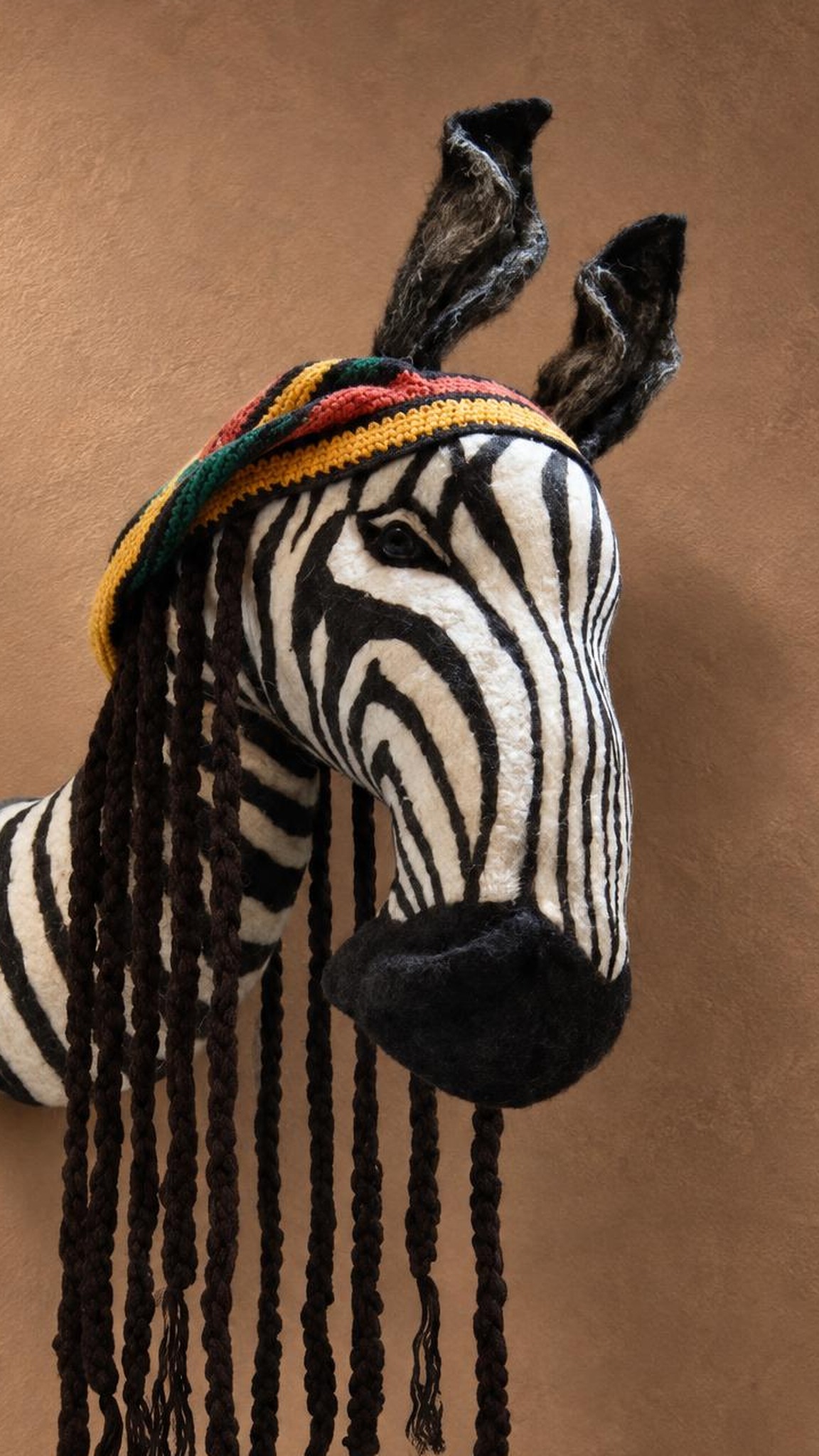 Custom zebra head plush, handmade faux taxidermy with hand-sewn stripes, a striped cap and braided yarn locks