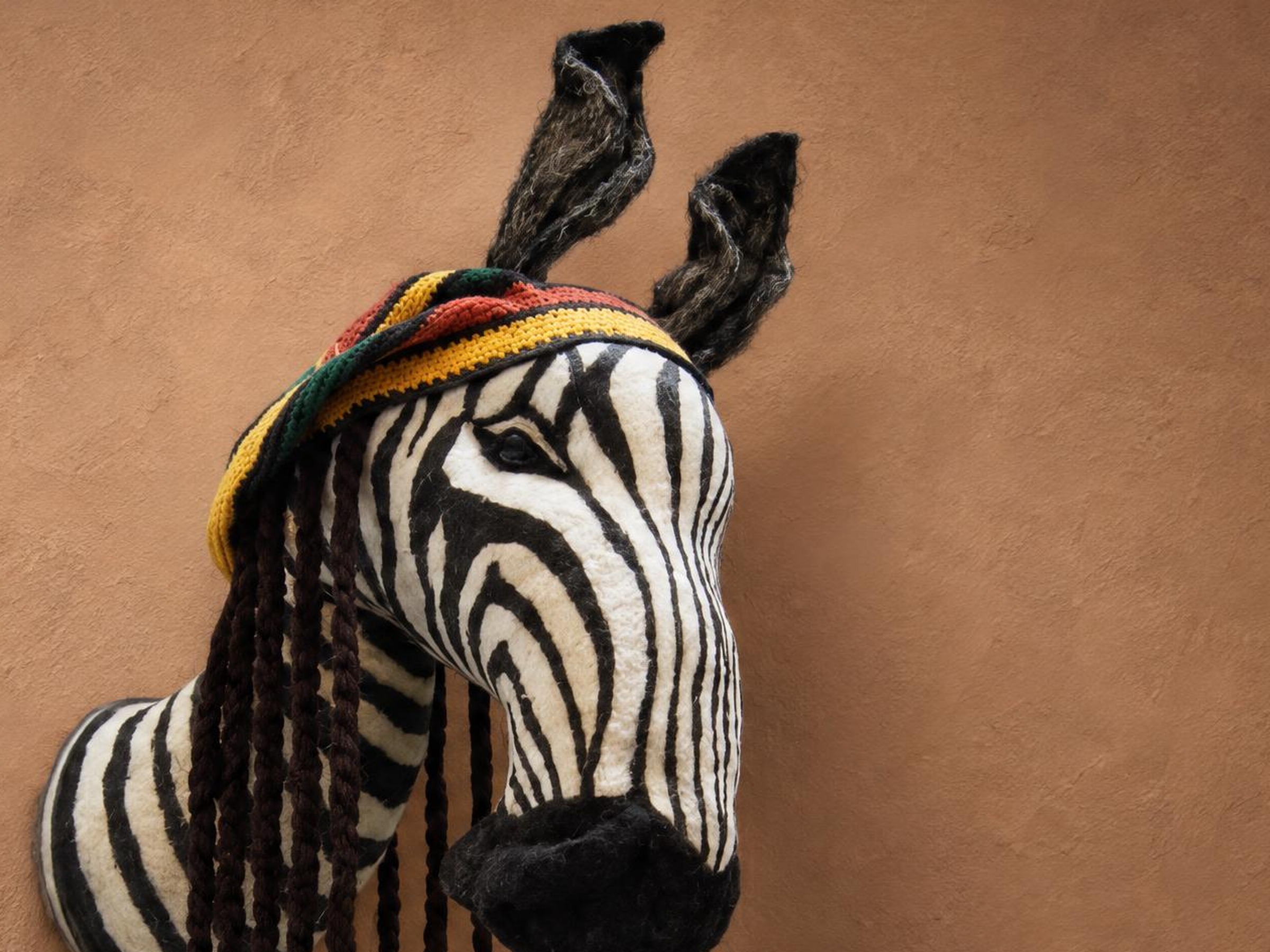 Custom zebra head plush with a striped cap and yarn braids Custom zebra head plush, handmade faux taxidermy with hand-sewn stripes, a striped cap and braided yarn locks