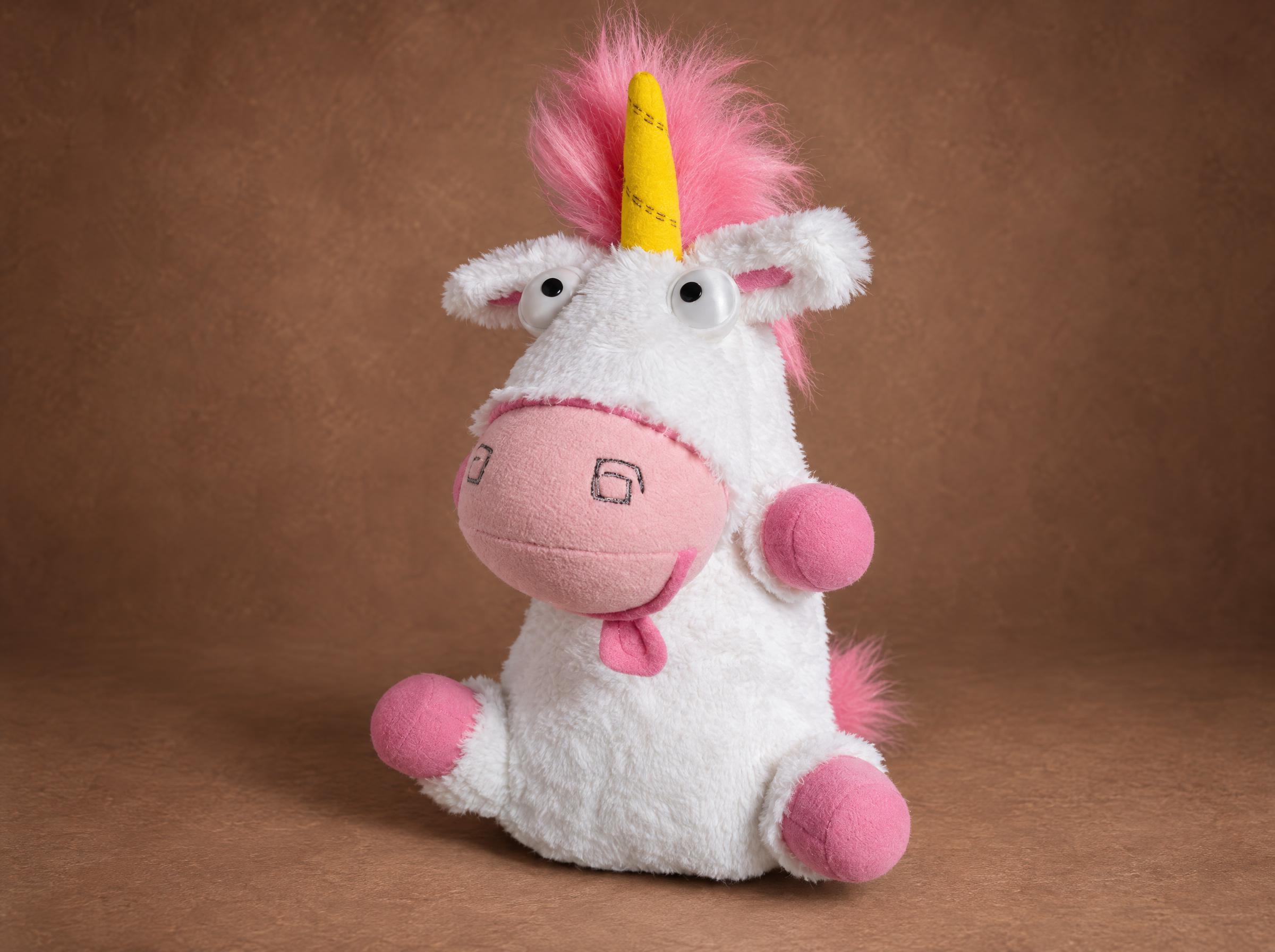 Despicable Me unicorn plush with its pink tongue out and fluffy pink mane, a custom stuffed unicorn sewn to order
