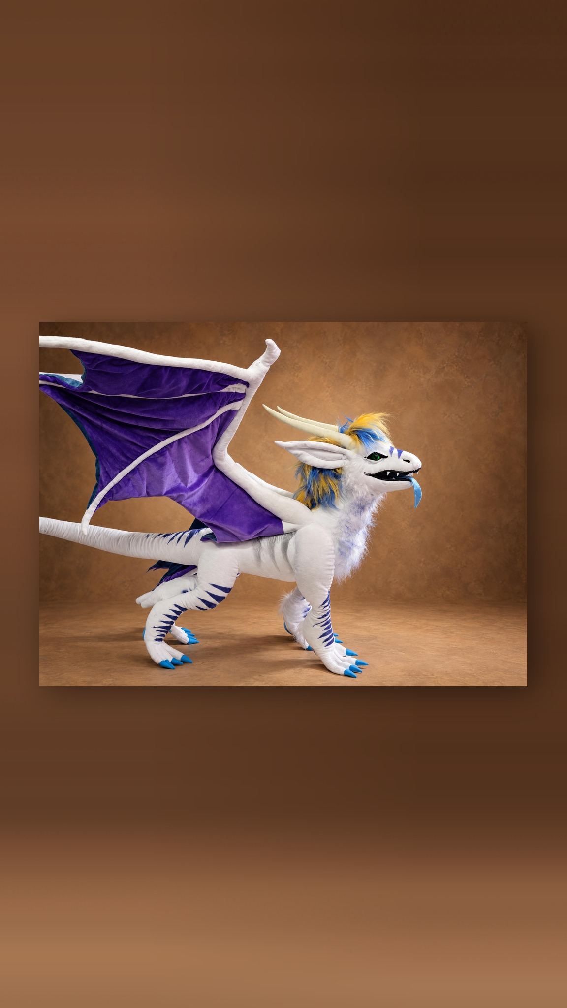 Dragon OC plush sewn to order, violet wing raised over a long white striped tail, blue tongue and green eyes