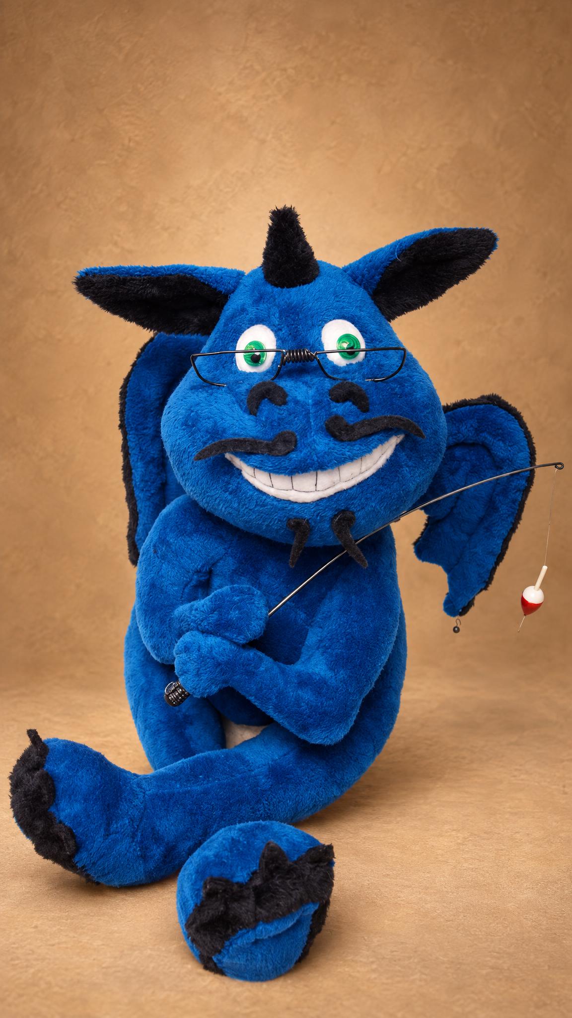 Look-alike dragon plush with wire glasses and a fishing rod, handmade to order as a gift for him