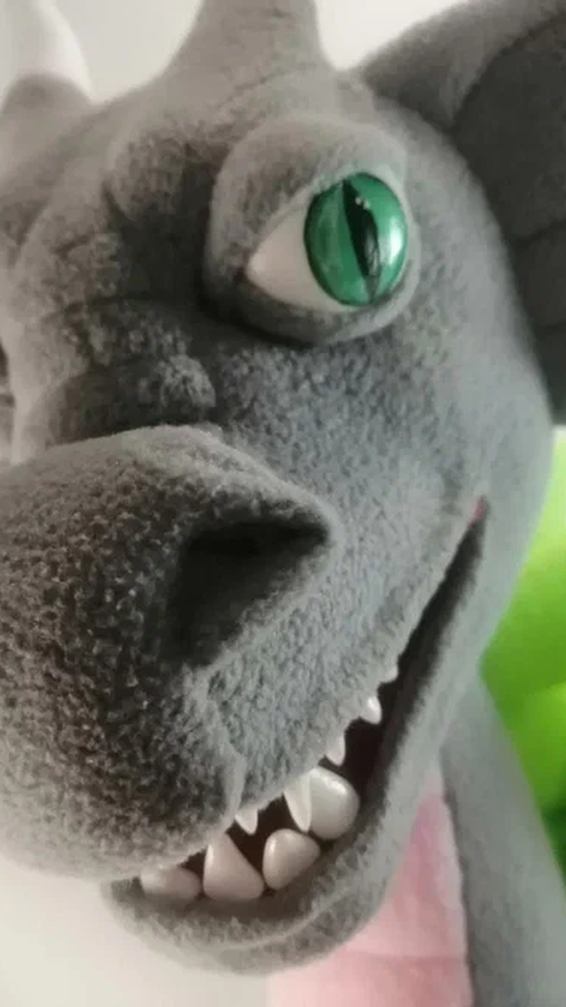 Esports dragon plush snout in soft gray fleece with white teeth and a green slit eye, a handmade mascot to order