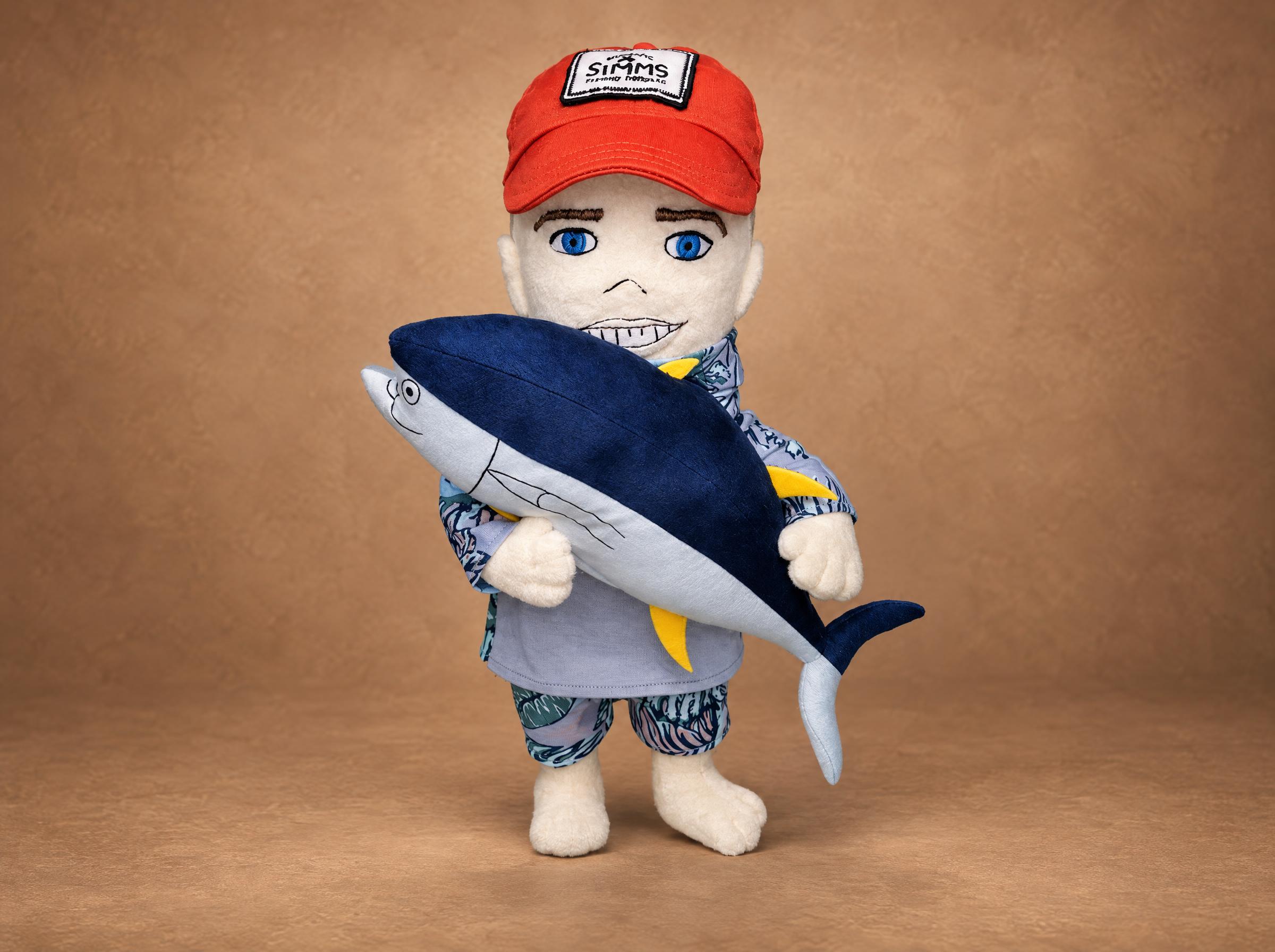 Custom fisherman doll sewn from photos: orange cap, leaf-print fishing shirt and a big plush tuna in his arms