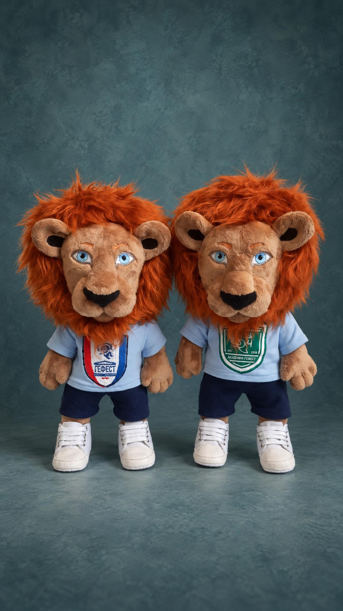 Two custom football club lion mascot plushes, one with the Gefest crest and one for Gefest Academy, in sneakers