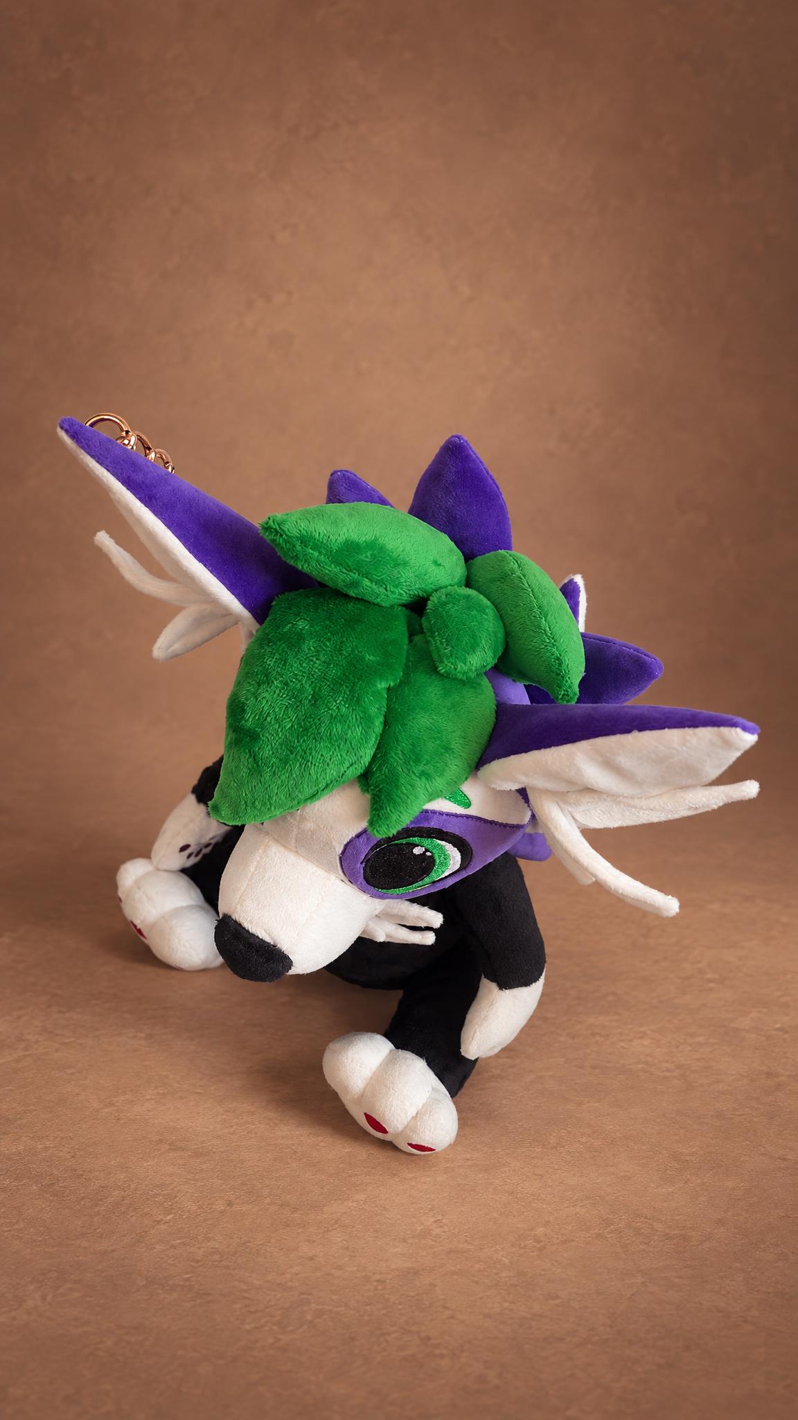 Handmade fursona plush seen from above, with green hair, purple spikes and white winged ears, custom made