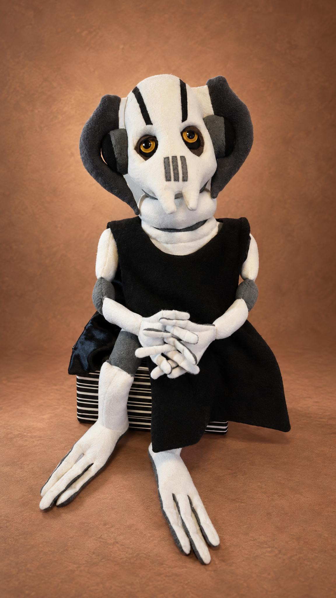 Custom General Grievous plush on a striped box, black cloak and long white claws, a handmade Star Wars toy