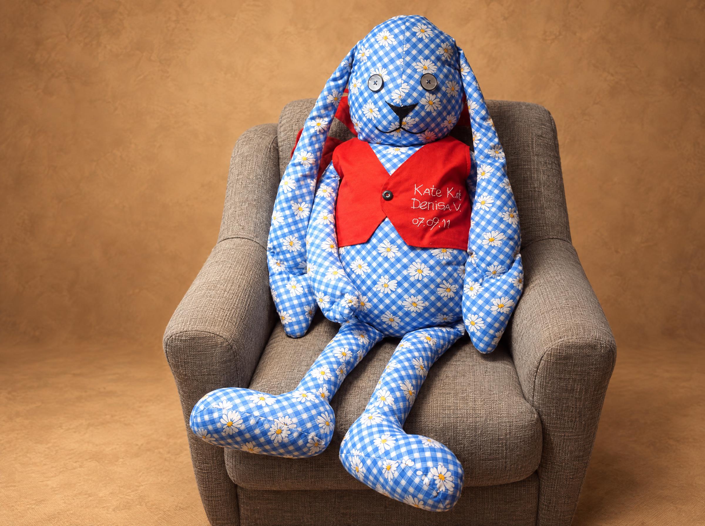 Giant bunny plush made to order, 1.2 m tall in blue daisy gingham and a red vest, sitting in an armchair