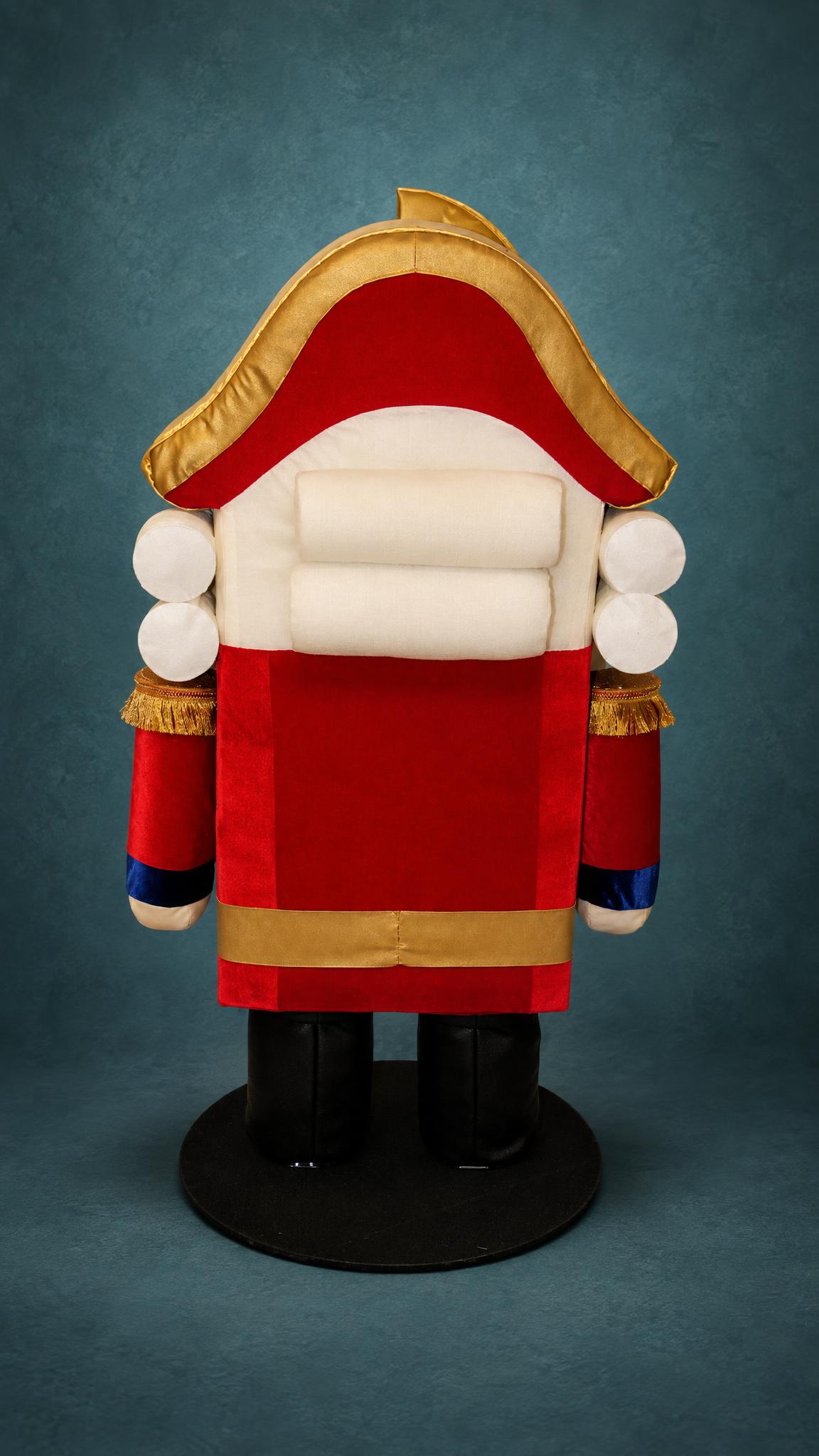 Giant Nutcracker plush with white rolled wig curls under a gold-trimmed hat and a red velvet coat, made to order