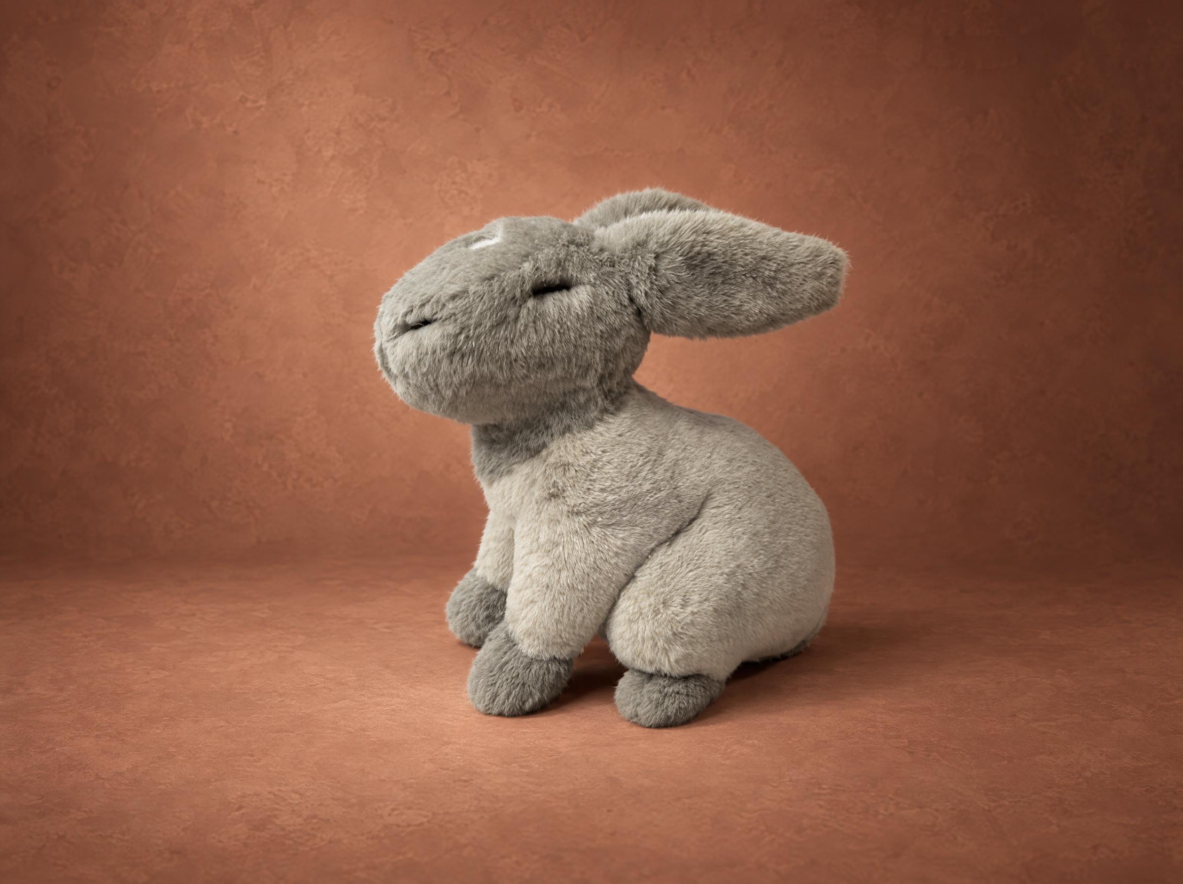 Gray bunny plush sewn to order from a drawing: long floppy ears, closed embroidered eyes, a calm little face