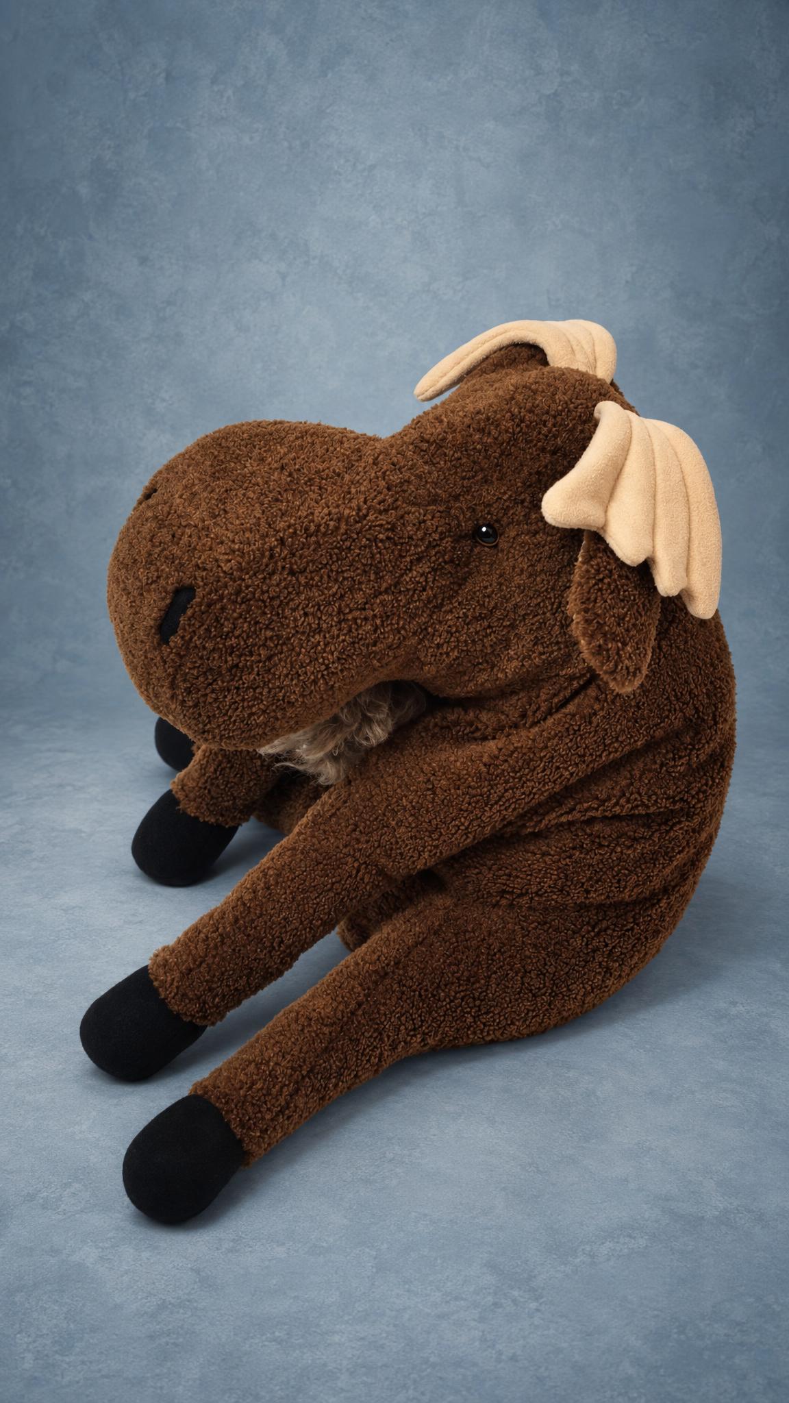Handmade moose plush toy sitting back on long legs, big soft muzzle and beige antlers, sewn to order