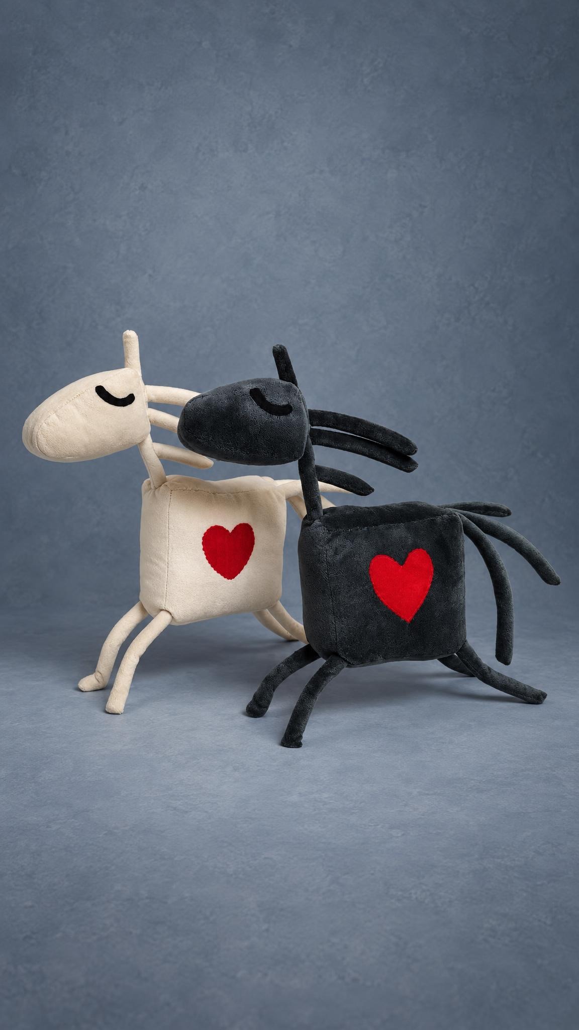 Two horse mascot plushes, cream and charcoal grey, each with a red heart, sewn to order for a riding club