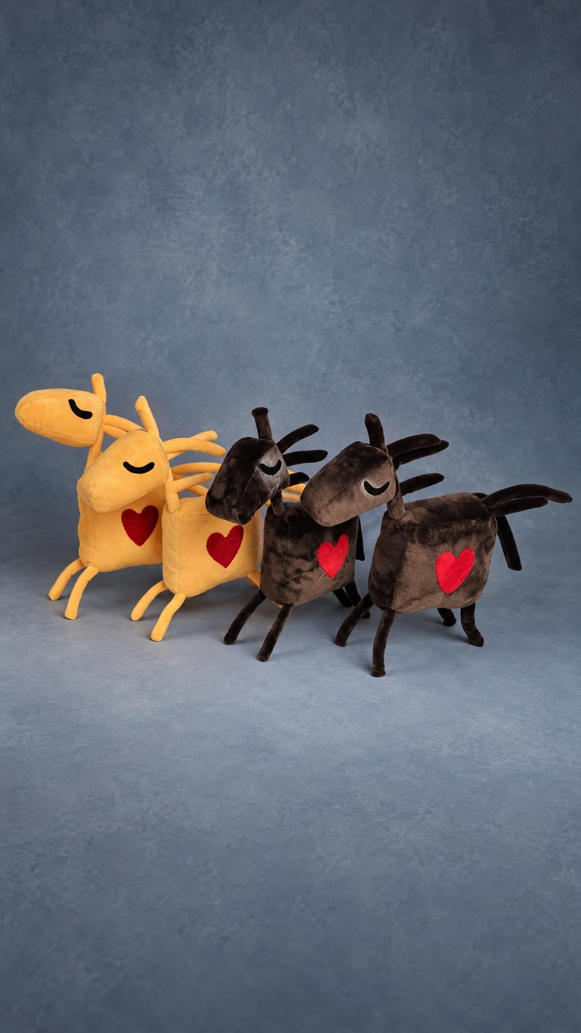 Four handmade horse mascot plushes, two warm yellow and two chocolate brown, each with a red heart