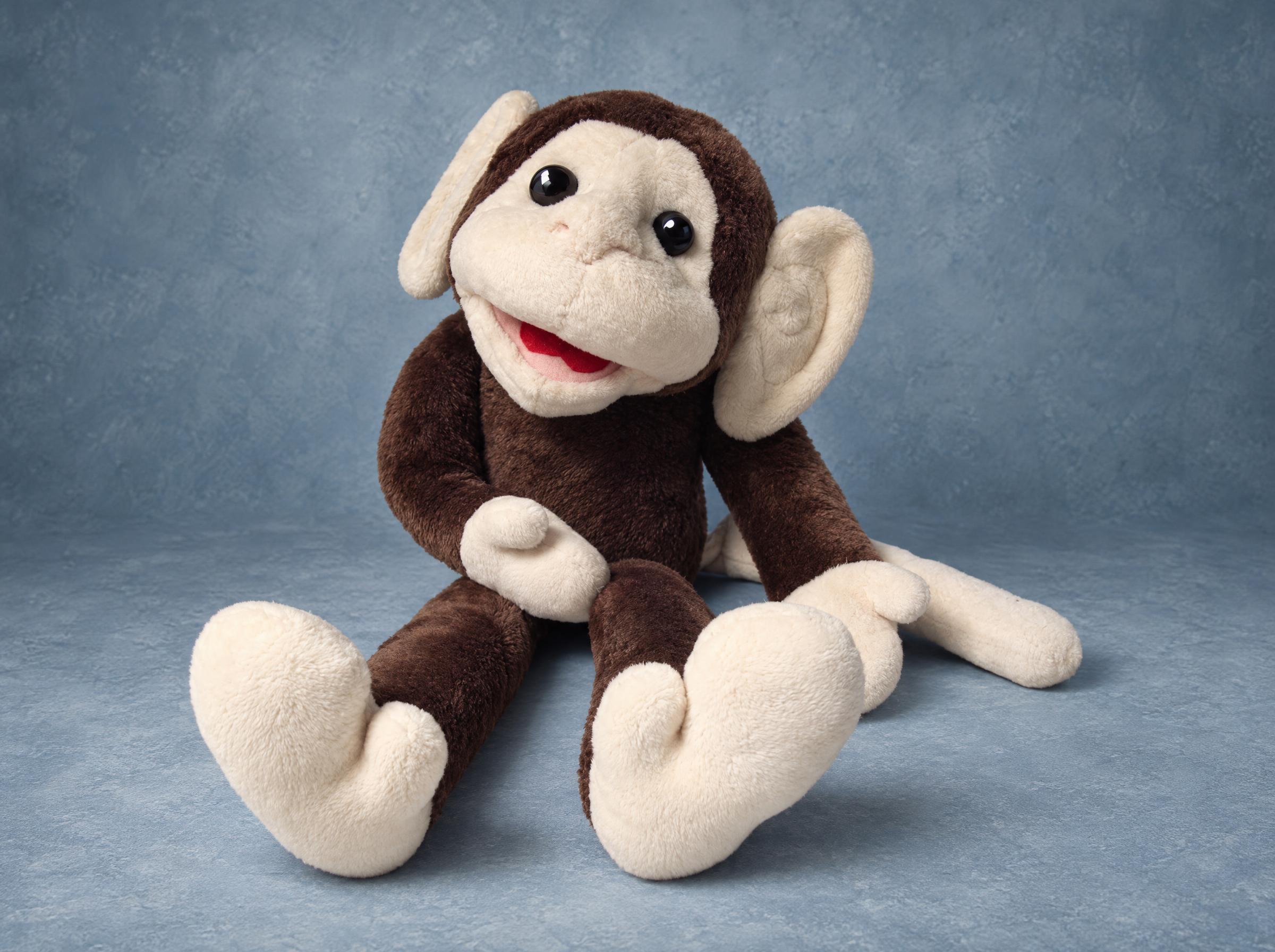Ika monkey plush, a lost childhood toy remade by hand from old photos: dark brown body, cream face, red smile