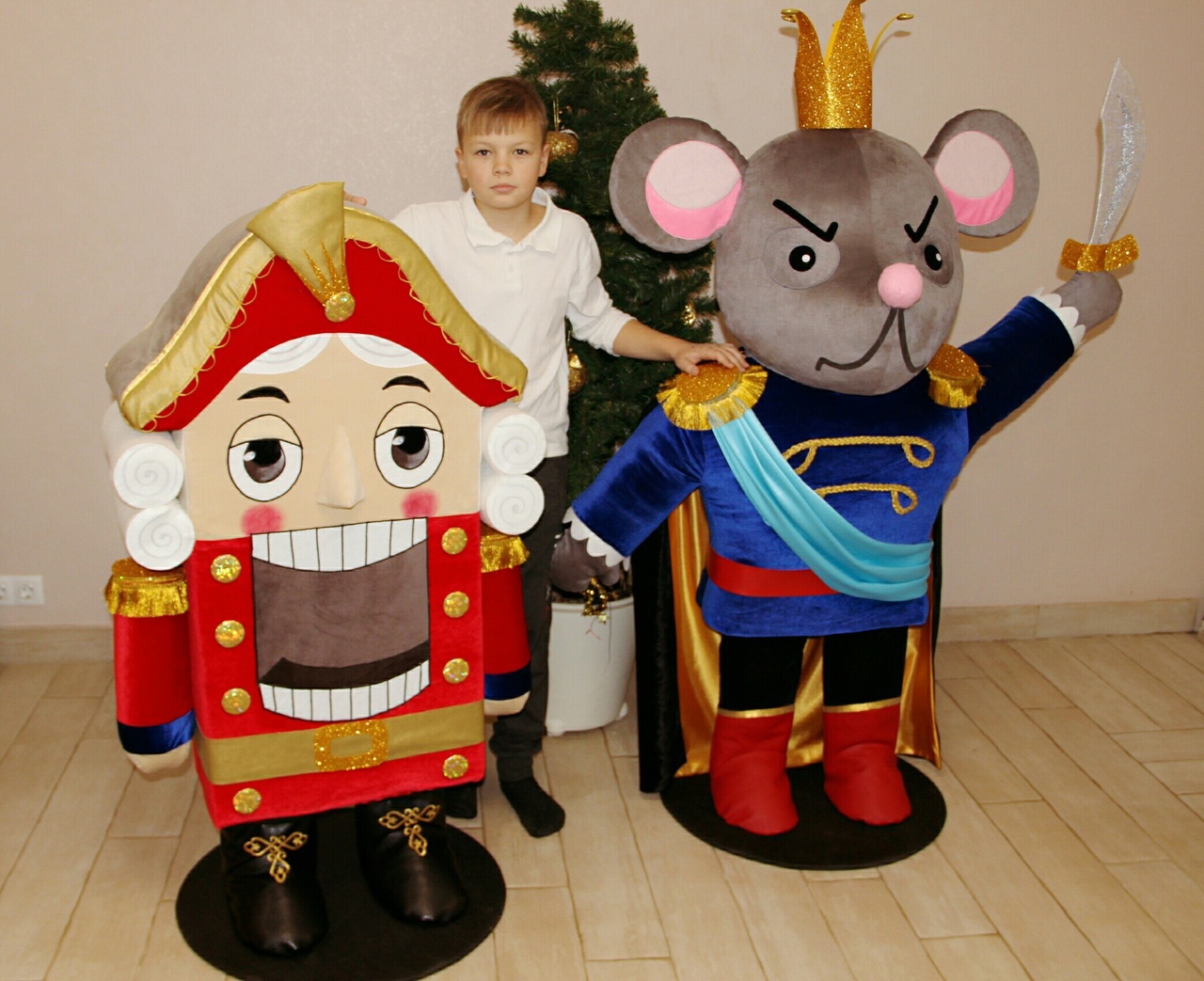Life size Nutcracker and Mouse King plush figures, each 1.2 m tall, next to a boy and a Christmas tree