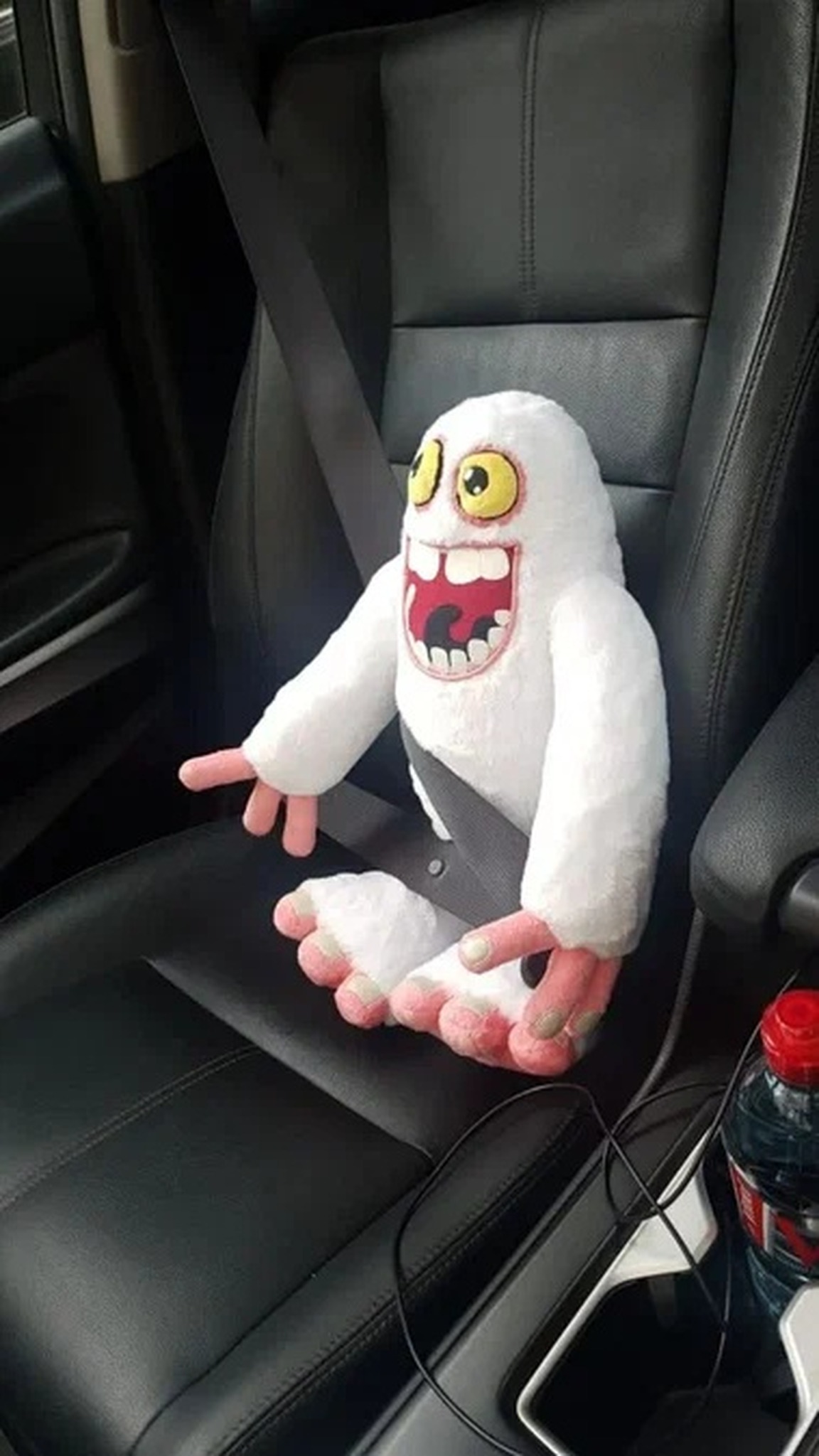 Custom My Singing Monsters plush of Mammott sitting in a car seat with the seatbelt on, handmade to order
