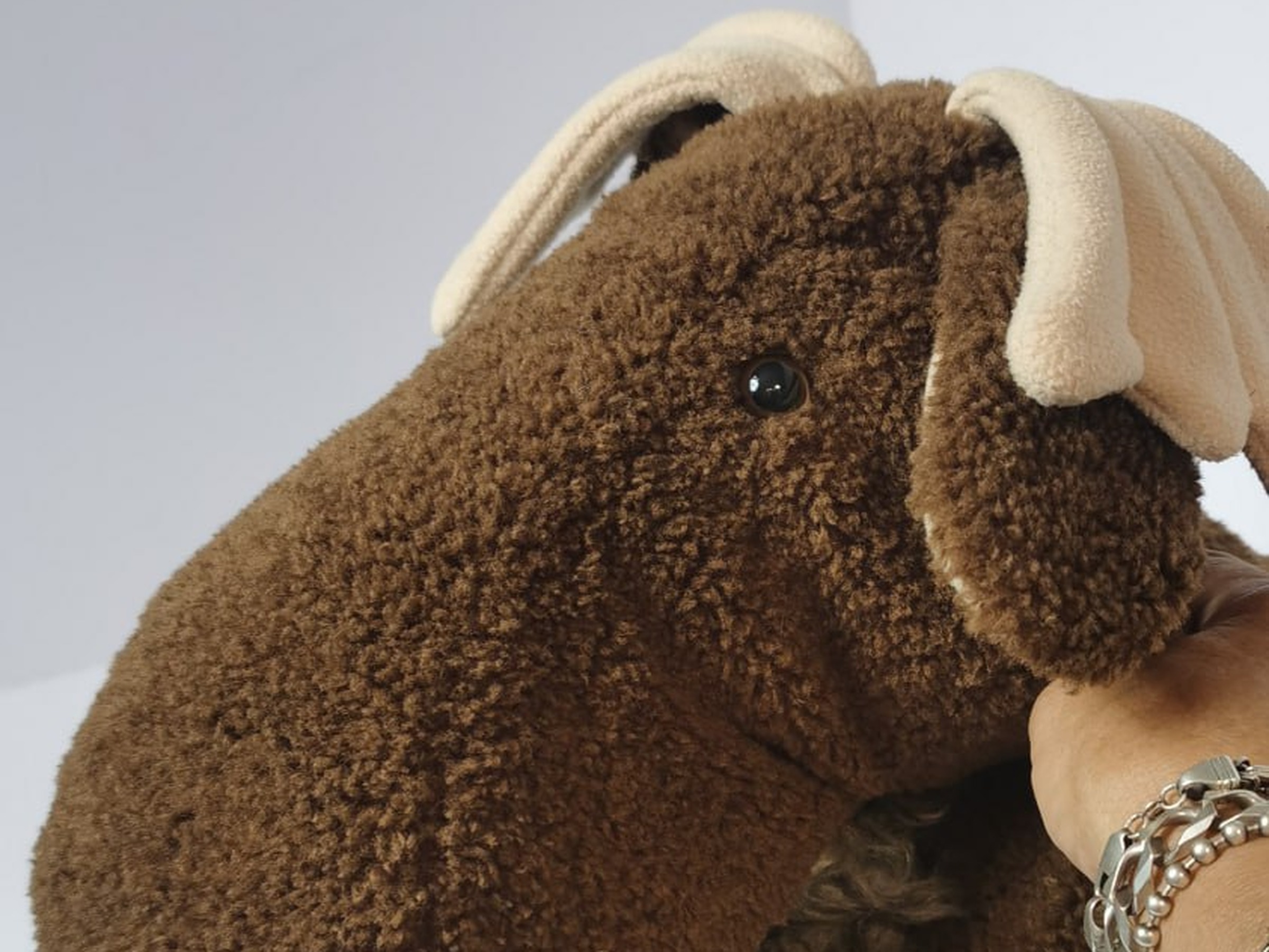 Moose stuffed animal for a collector Moose stuffed animal for a moose collector, a hand with bracelets hugging its curly brown neck, handmade