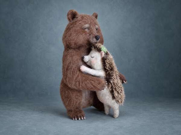 Needle felted bear and hedgehog made to order from a tattoo: a brown wool bear hugs a sleepy grey hedgehog