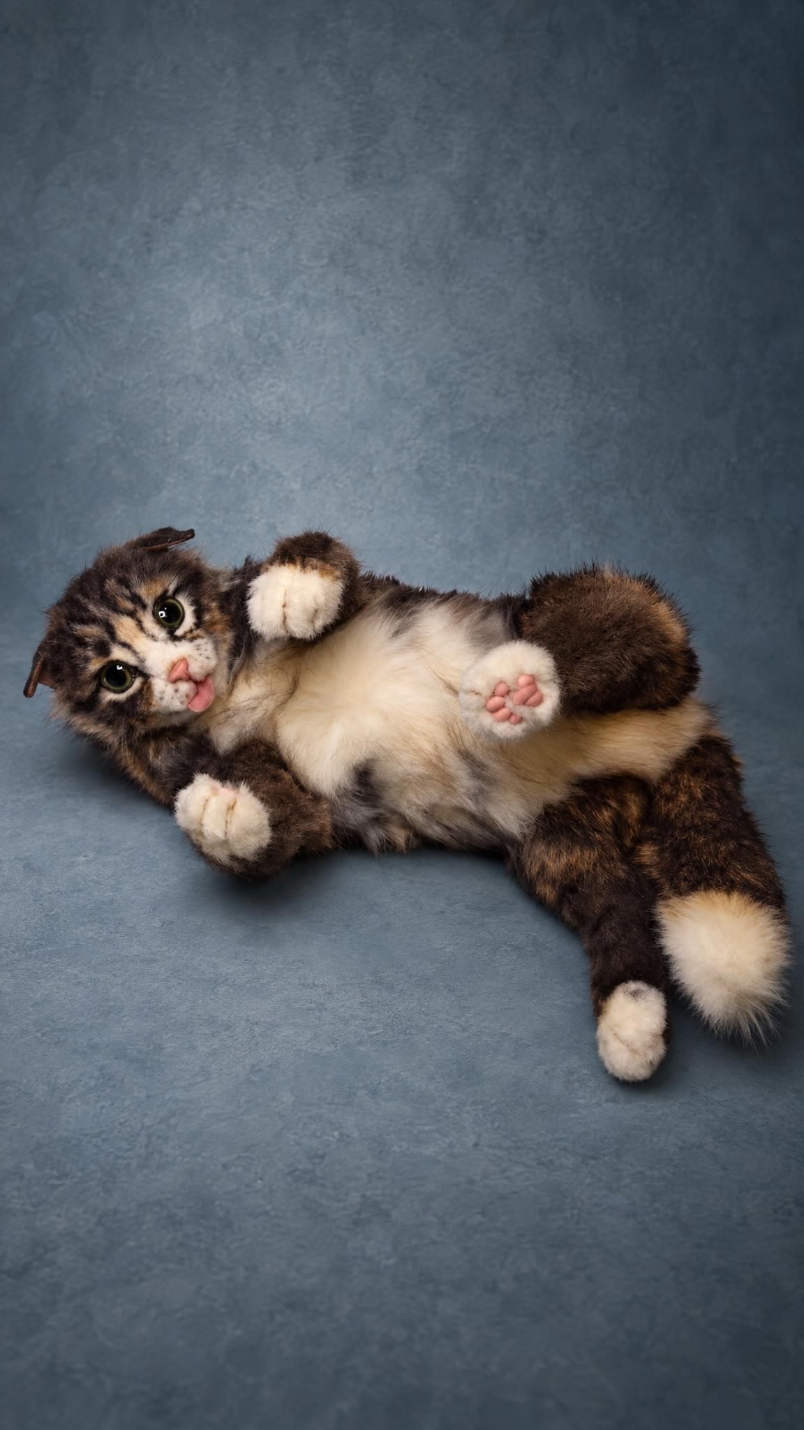 Handmade tabby cat stuffed animal rolling on its back, pink paw pads and a white-tipped tail, a pet replica