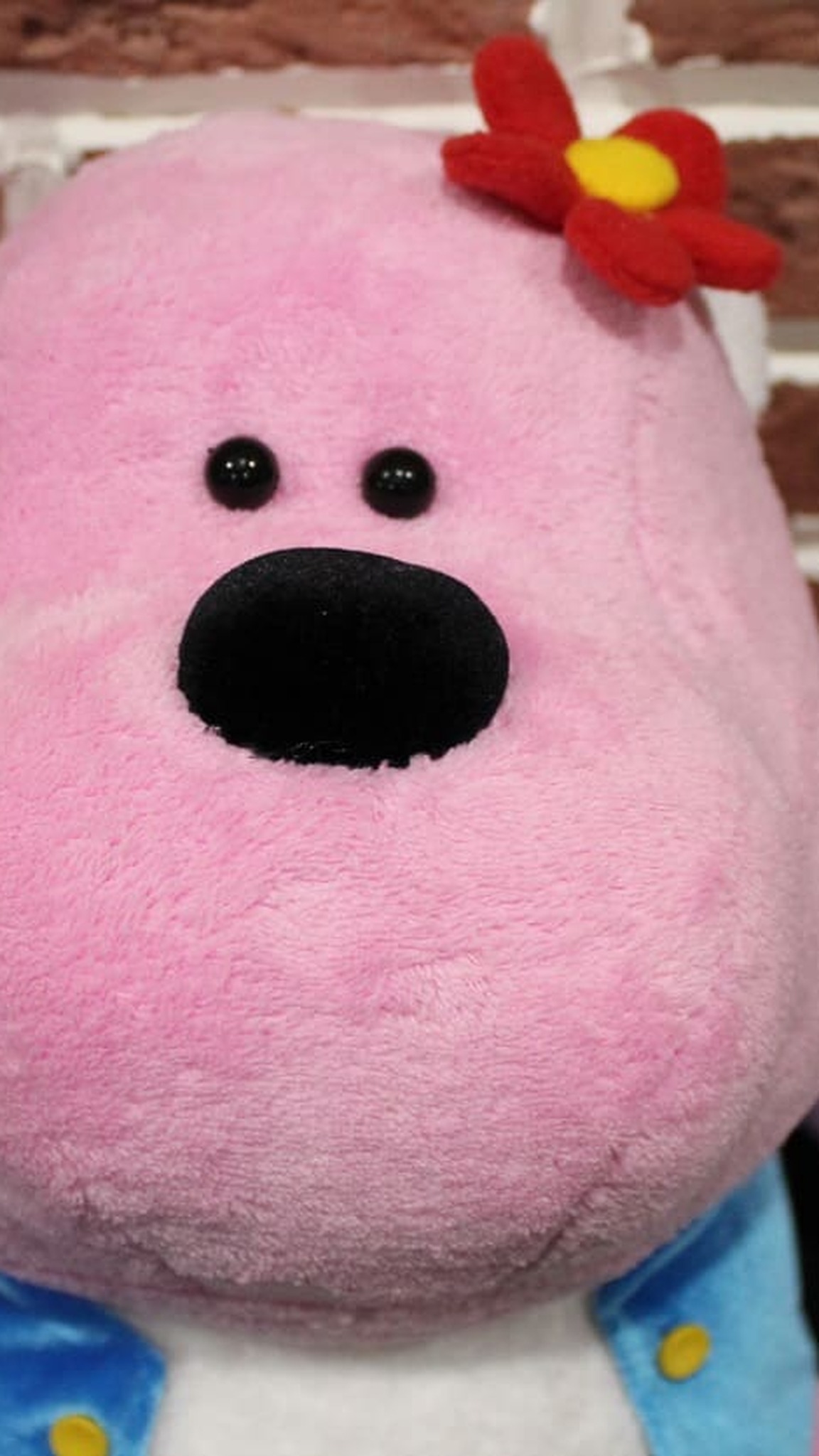 Pink gorilla mascot plush with a blue vest and red flower, a company character handmade to order