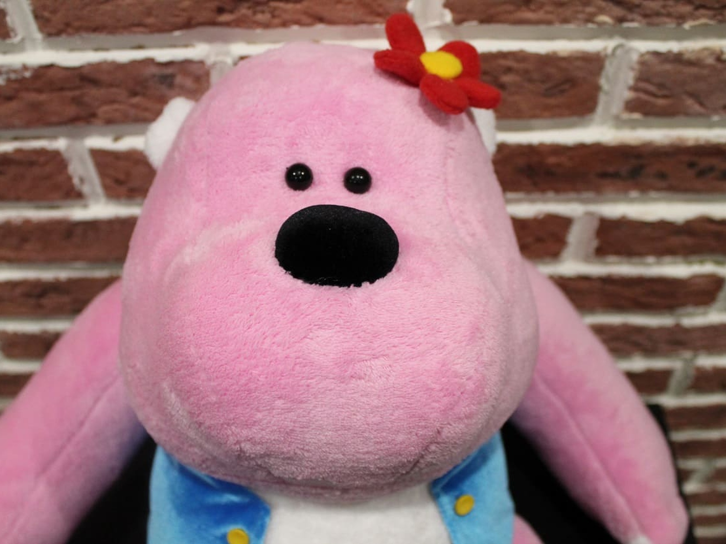 Pink gorilla mascot plush in a blue vest Pink gorilla mascot plush in a blue vest with gold buttons and a red flower, a custom company character sewn to order