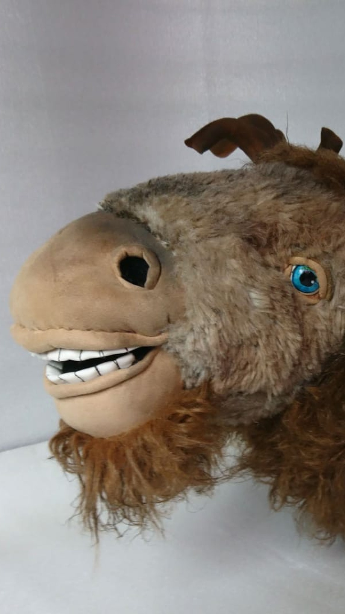 Plush taxidermy moose trophy facing left, bright blue eyes and faux fur beard, custom sewn for a cabin wall