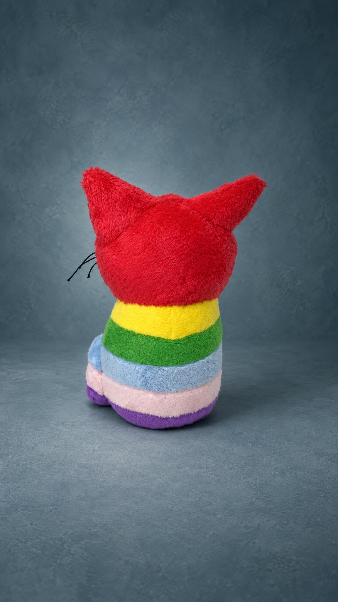 Custom cat plush from a kid's drawing: red head and ears over yellow, green, blue, pink and violet stripes