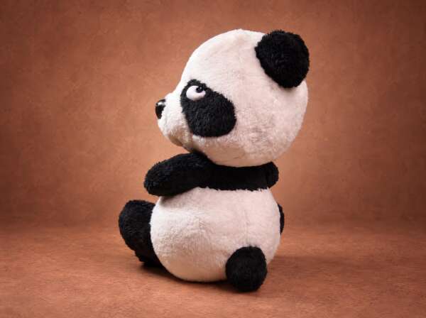 Resentful panda plush looking away with half-closed eyes and crossed arms, a mood sticker sewn to order