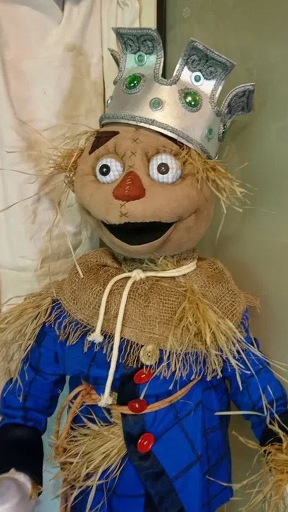 Scarecrow King doll face with big round eyes, an orange nose and a green-jeweled crown, a custom Oz doll