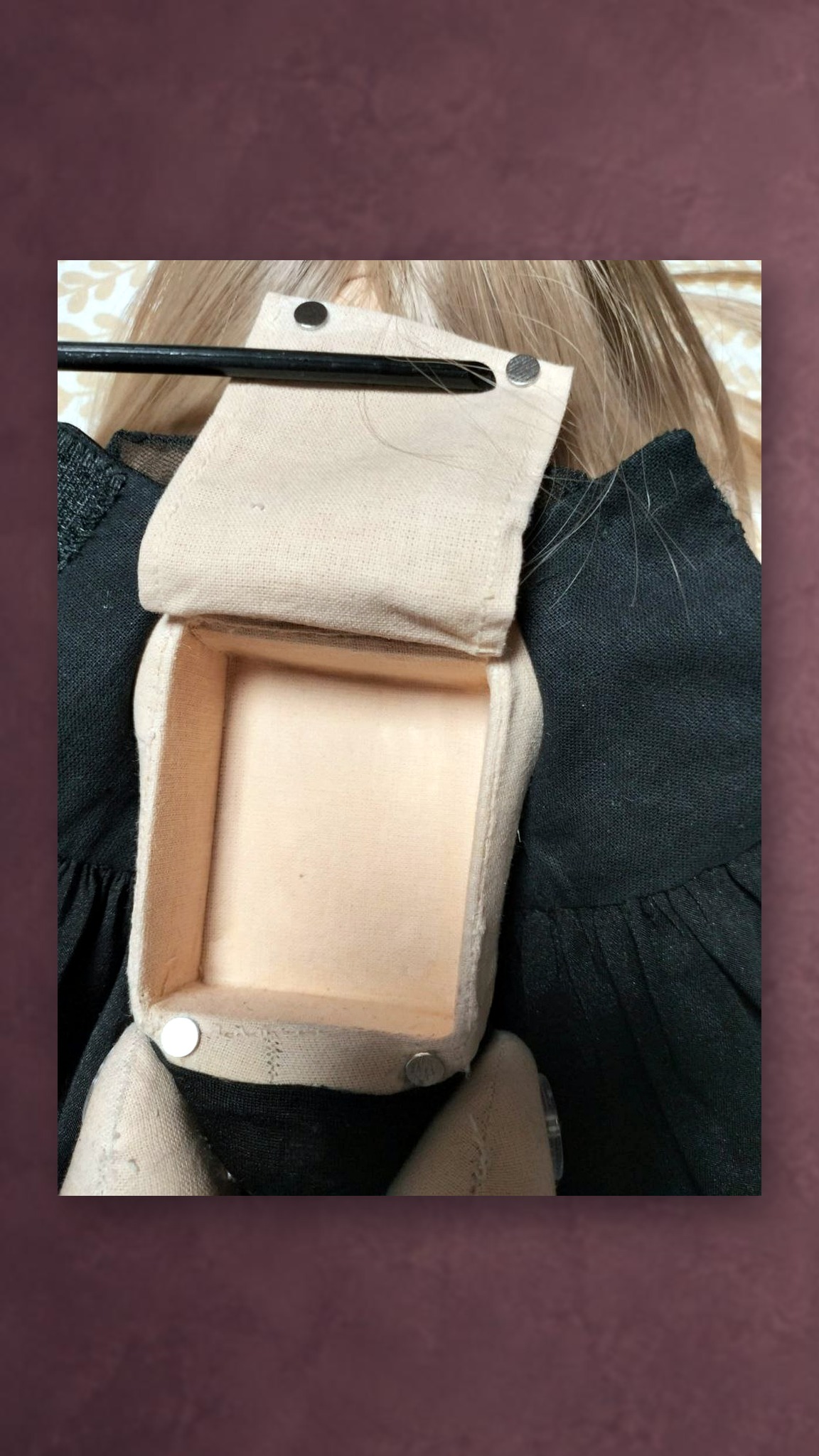 Talking portrait doll with a voice module pocket: fabric compartment with metal fasteners on the doll's back