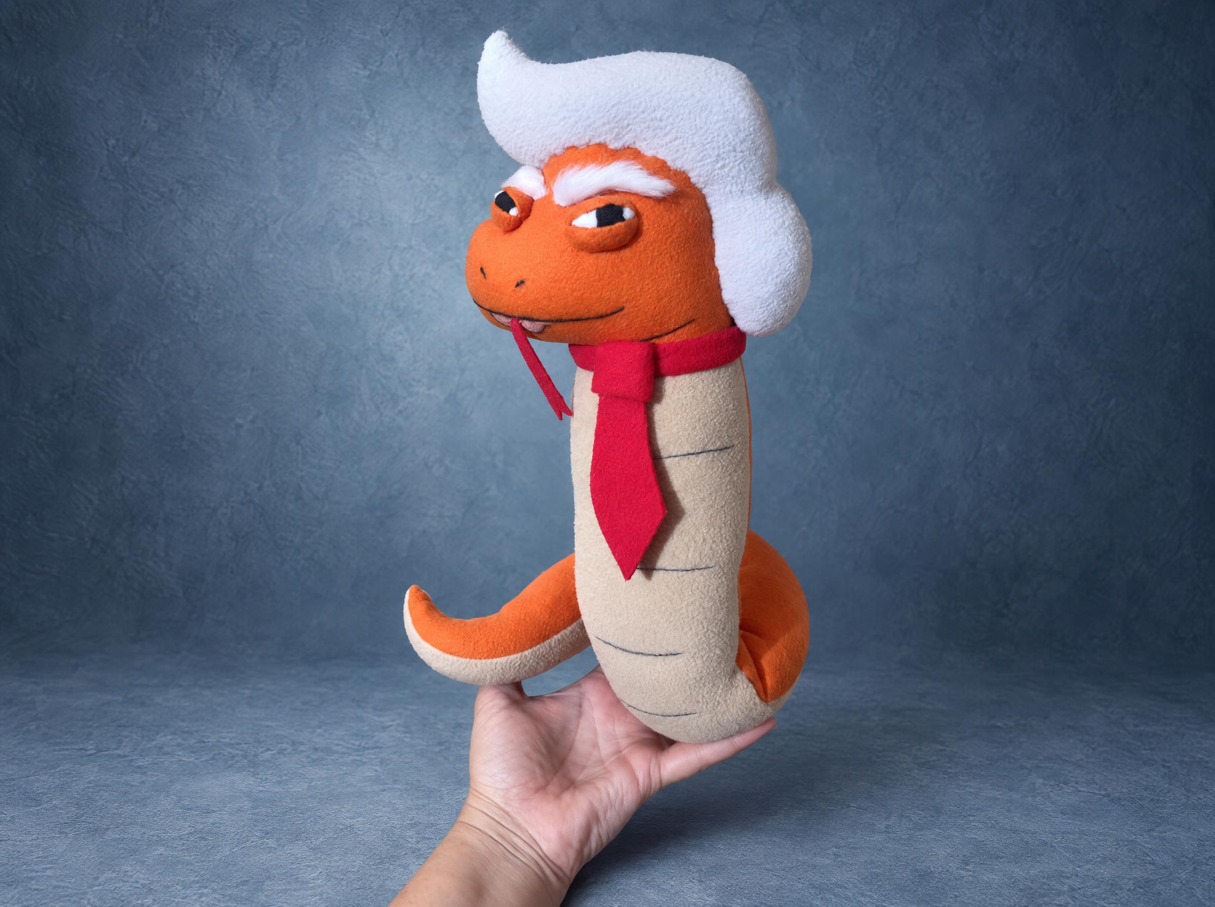Trump snake plush, smirk and forked tongue Trump snake plush with a smirk, a red forked tongue and a red tie over a cream belly, a famous-person parody sewn to order