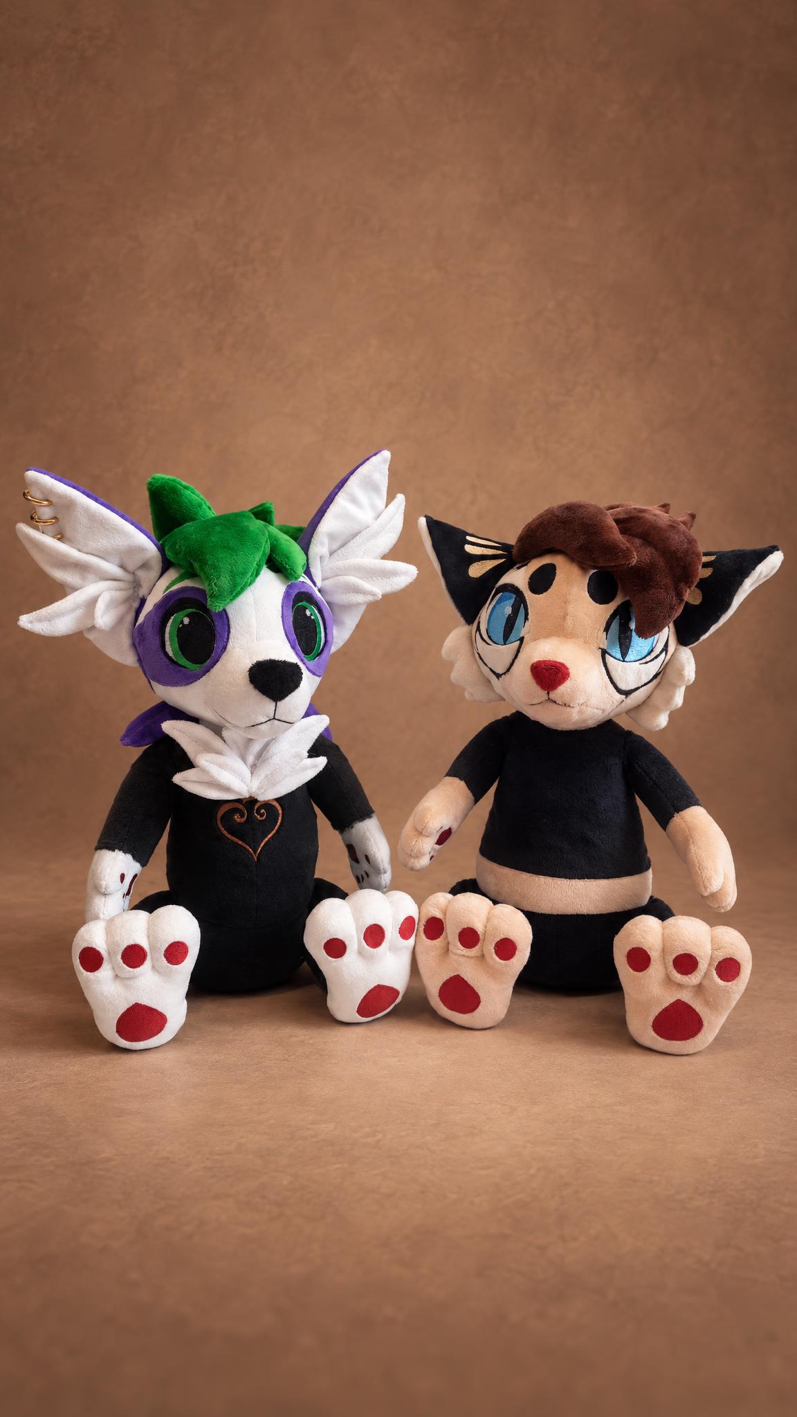 Two custom furry plushies side by side, a white OC with purple eye patches and a cream cat fursona, handmade