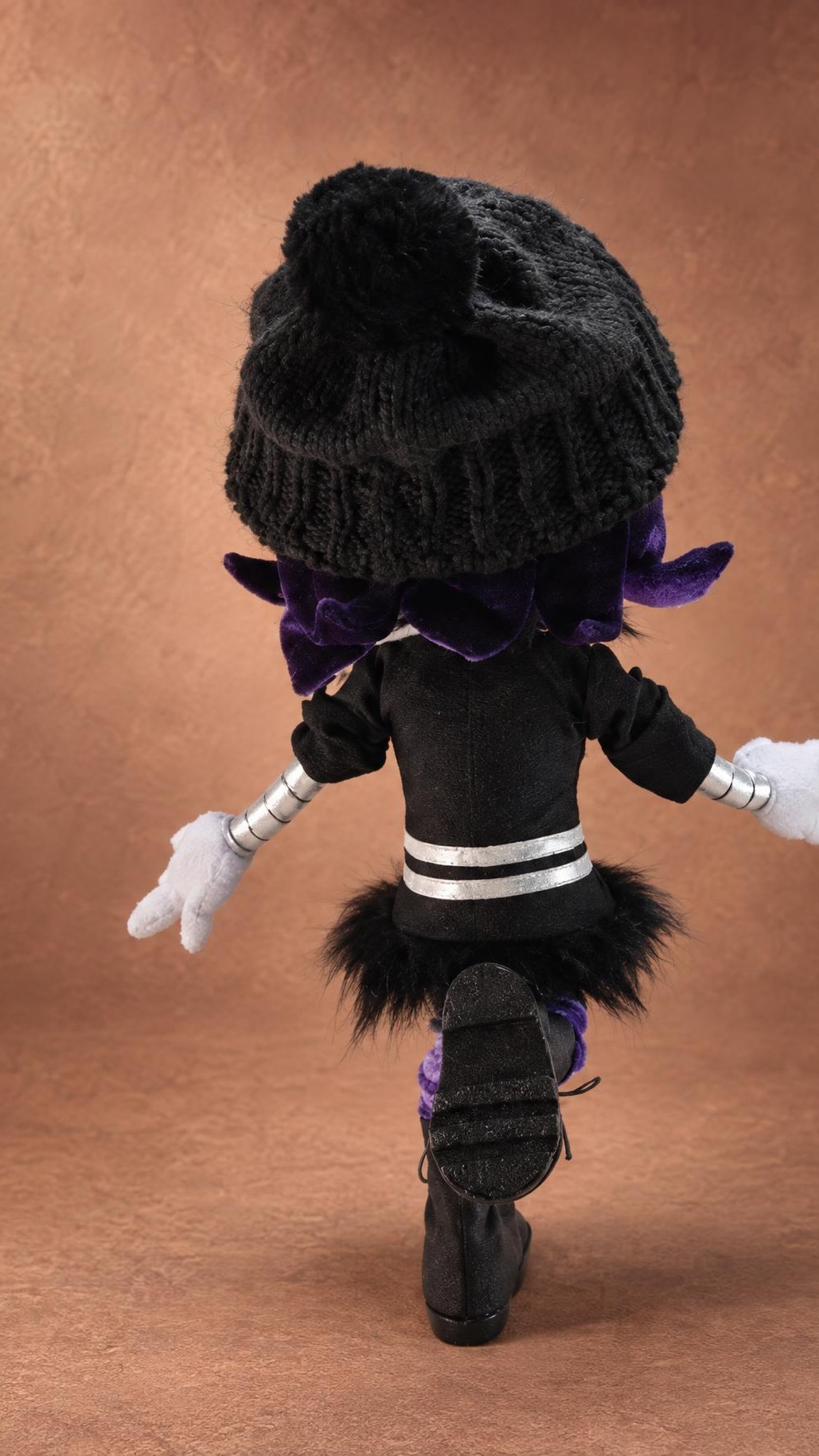 Uzi plush from behind: grey beanie, purple hair and black fur skirt, a Murder Drones doll made to order