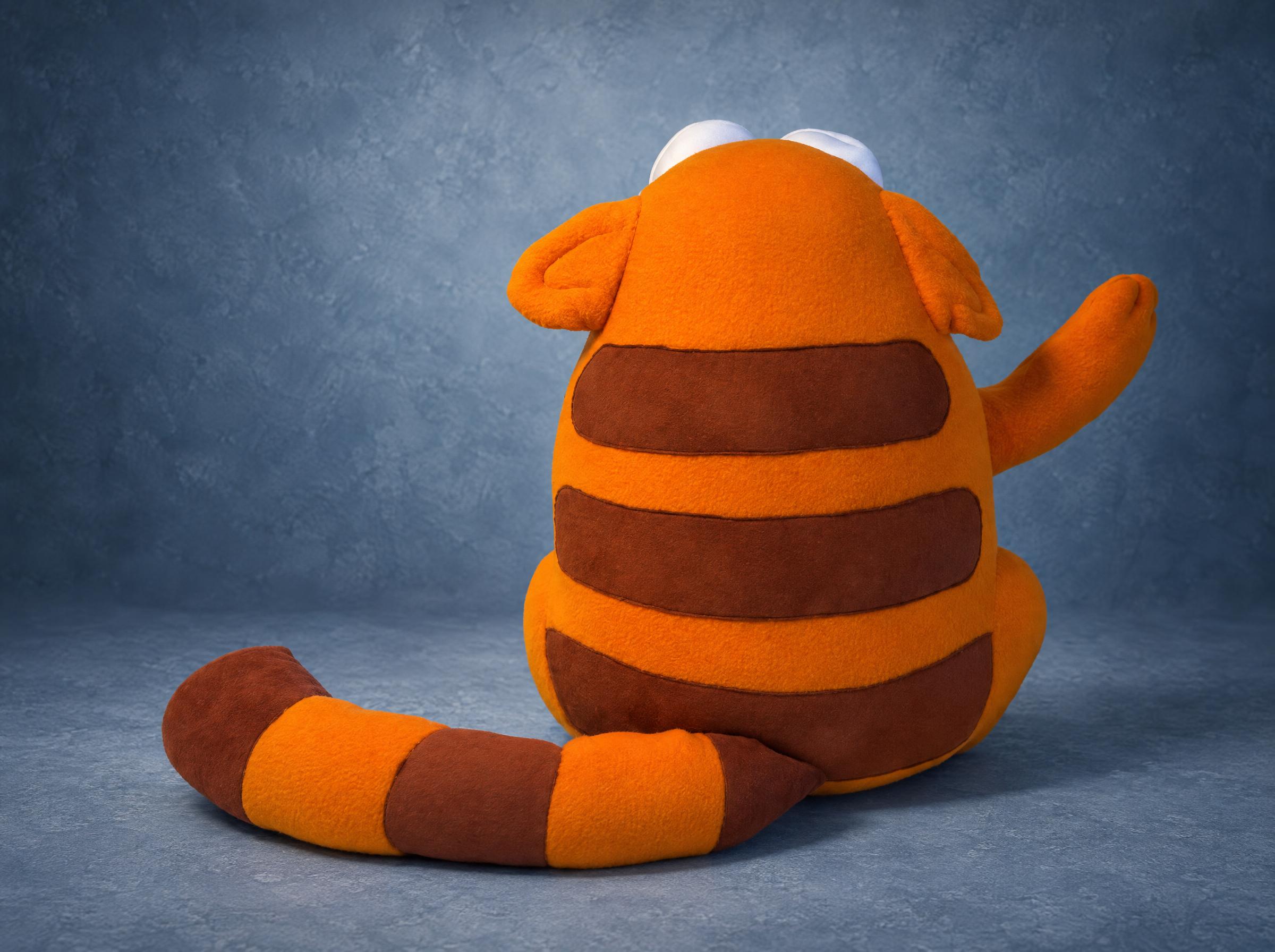 Viber cat plush from behind, brown stripes Back of the Viber cat plush: orange fleece with brown stripes across the back and a striped tail, sewn to order